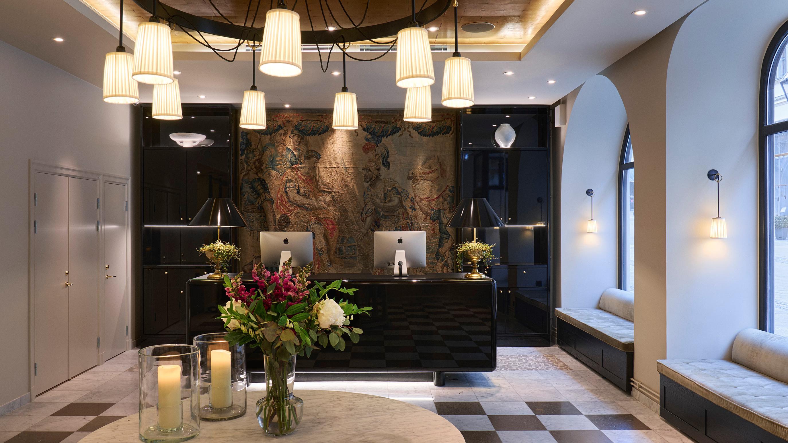 The hotel lobby with dark stone walls, brass accents, and hanging pendant lights