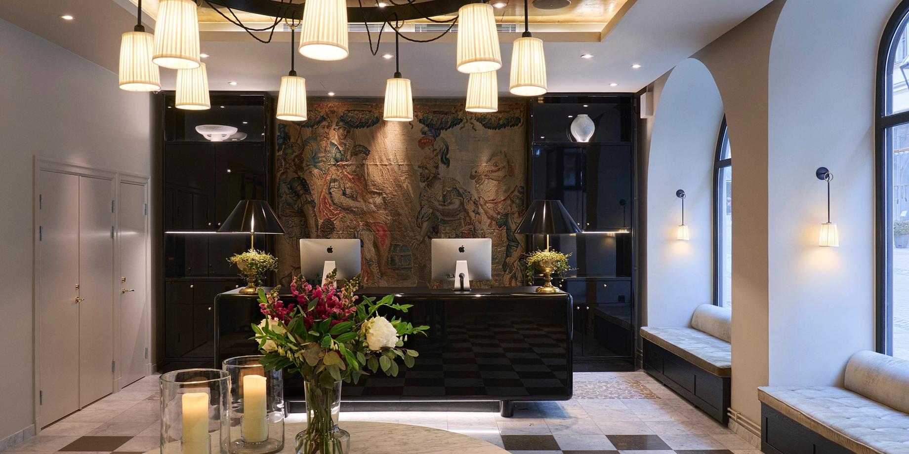 The hotel lobby with dark stone walls, brass accents, and hanging pendant lights