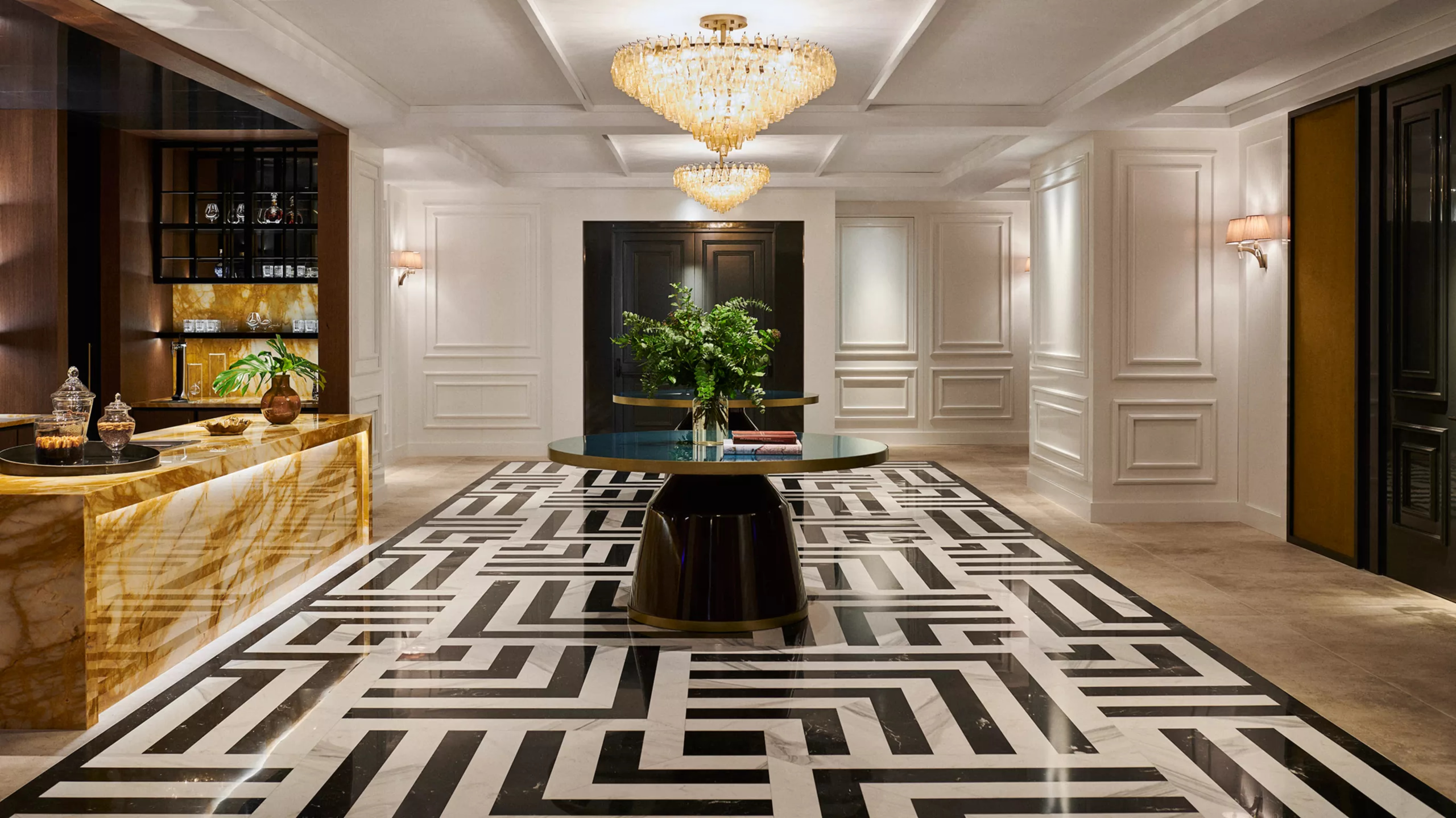 Rosewood Villa Magna: the lobby with black and white geometric flooring, crystal chandelier, and decorative plants