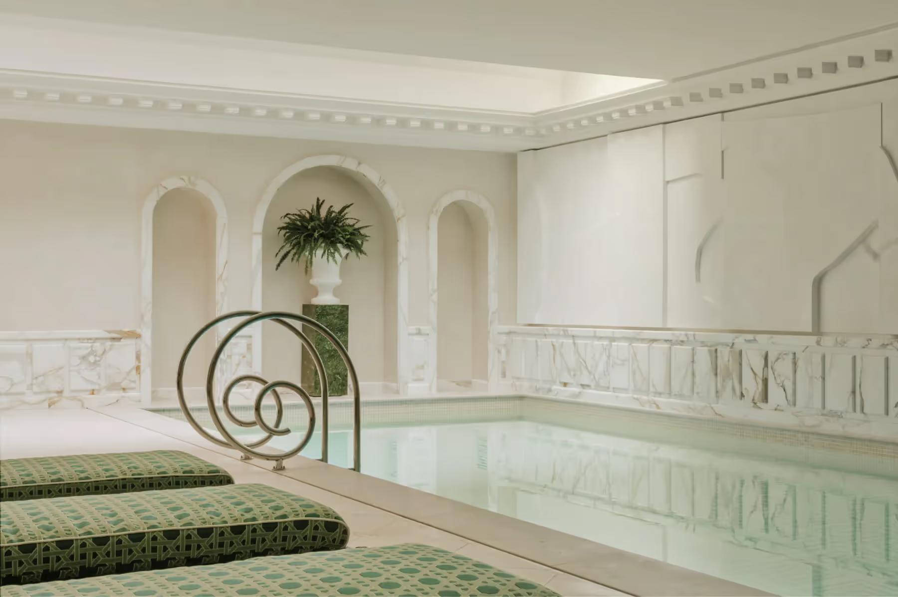 Spa facility with pale tile pool, arched architectural detail, and potted plants