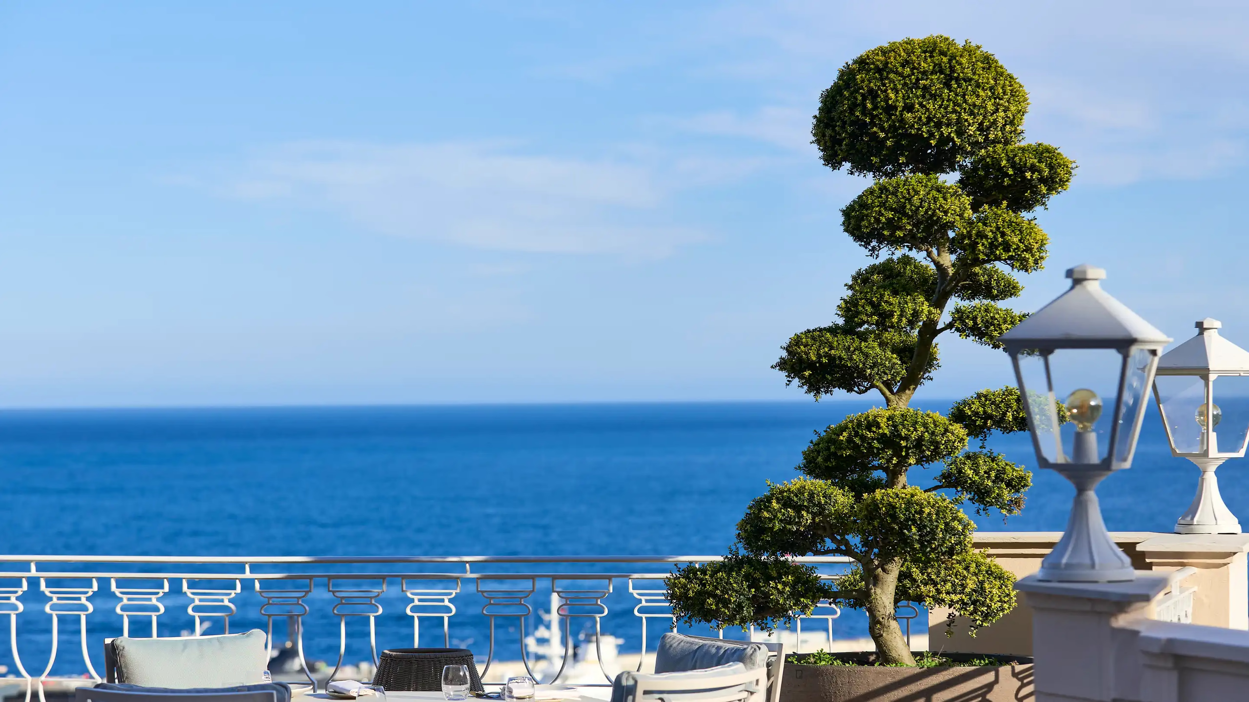 Seaside terrace with potted topiary and sweeping Mediterranean coastline