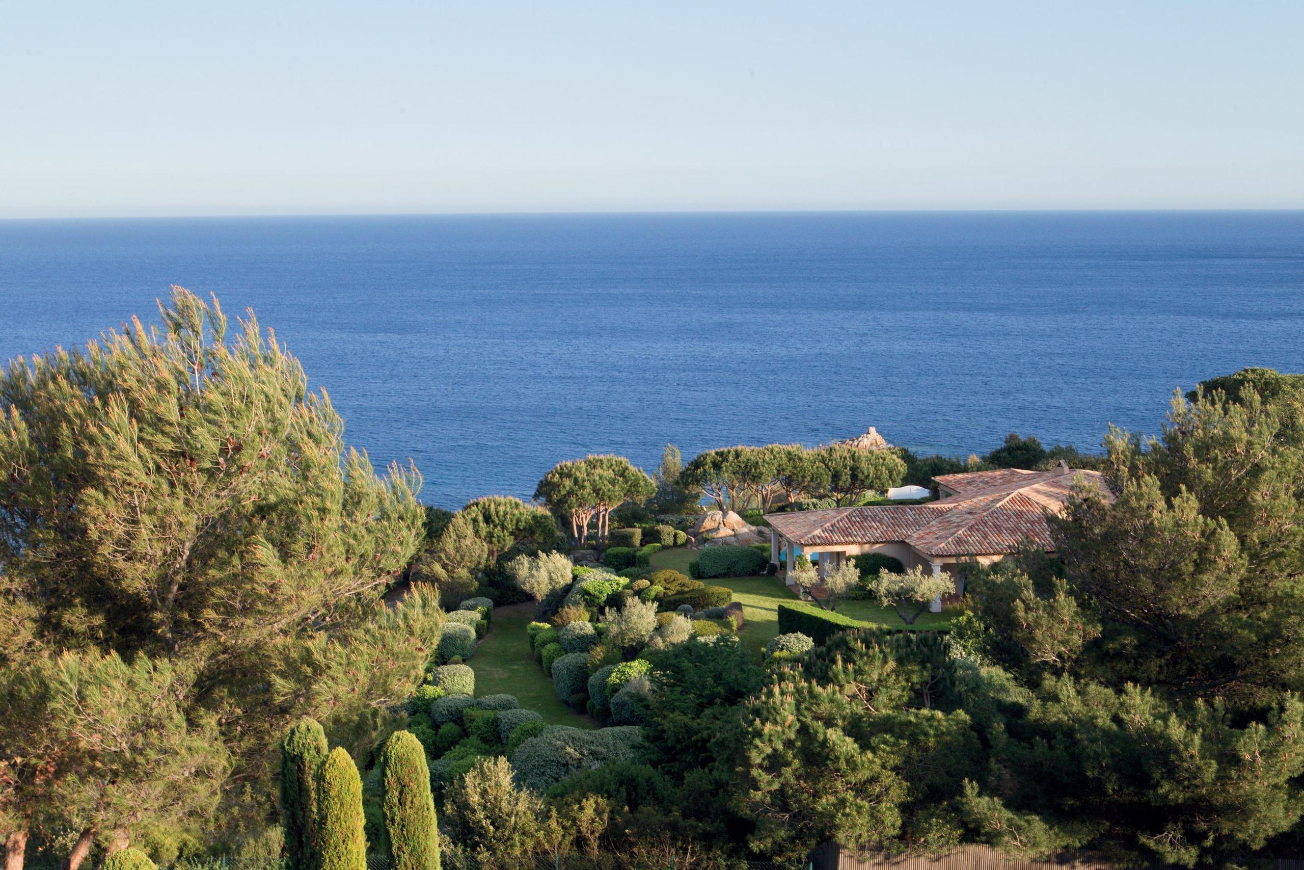 Aerial view of property set in hillside overlooking the sea