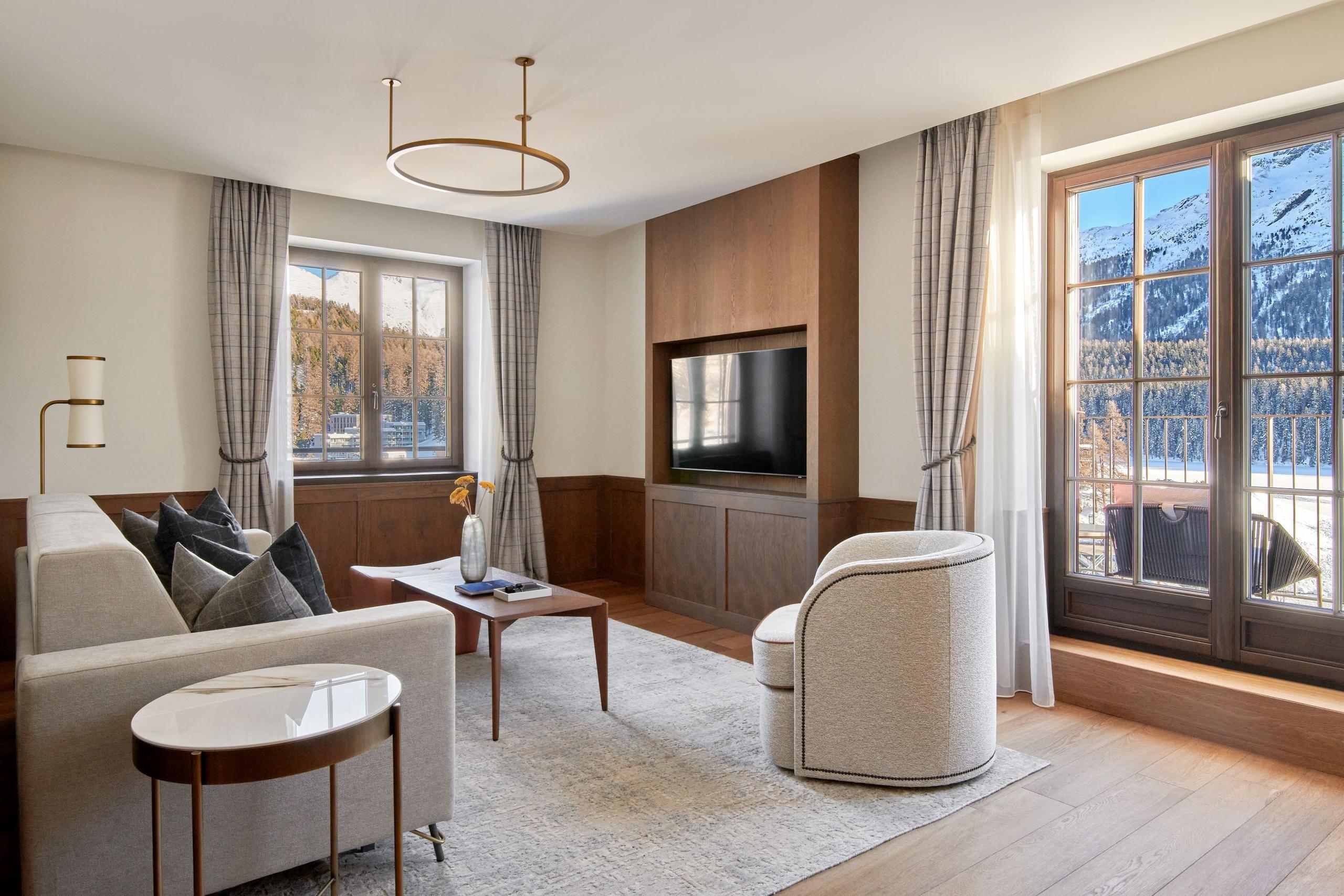 Grace La Margna St. Moritz: sitting room with wood paneling, upholstered seating, coffee table, and mountain views