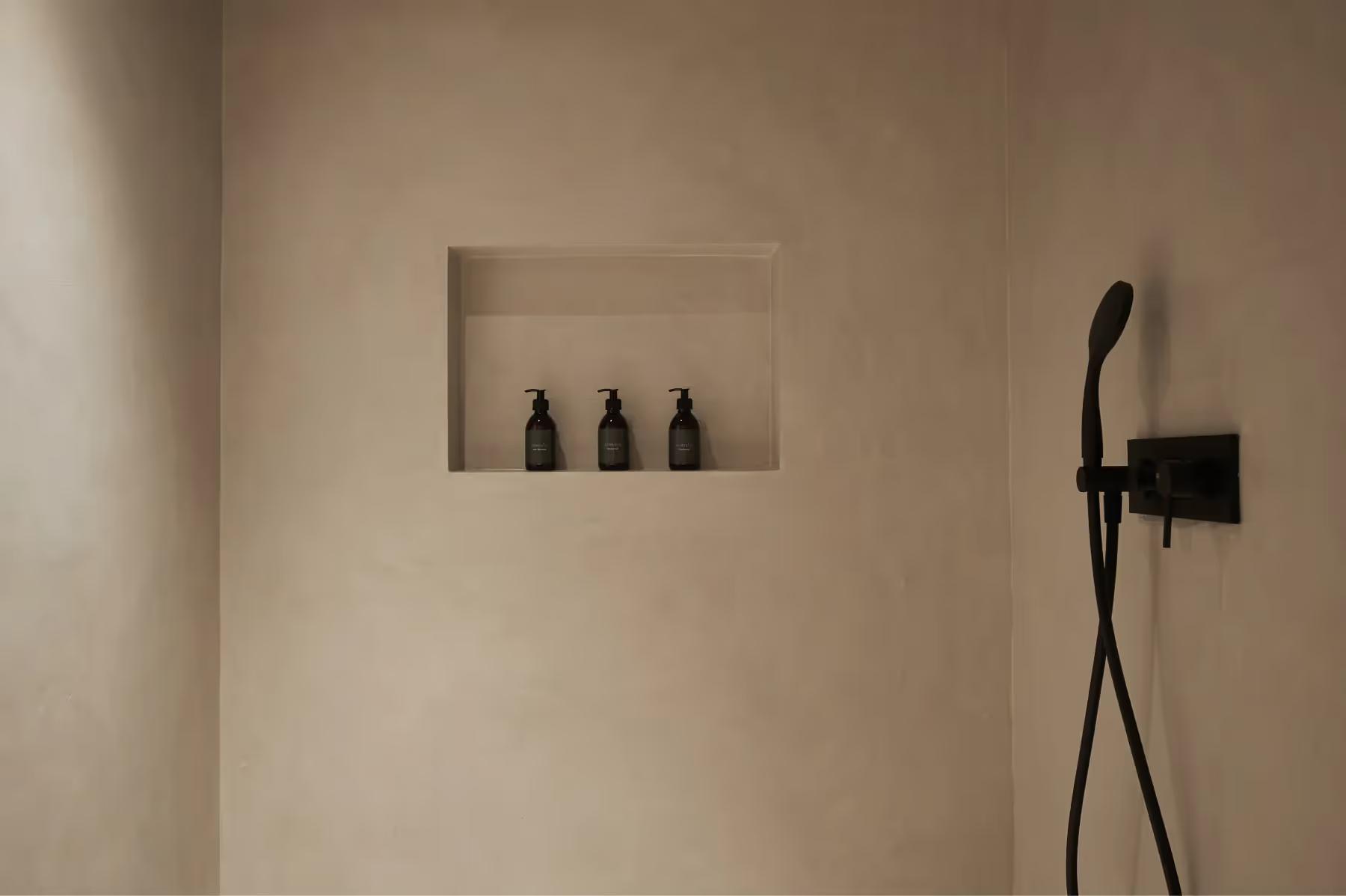 A bathroom vanity with warm lighting, wooden cabinetry, and minimalist natural stone fixtures
