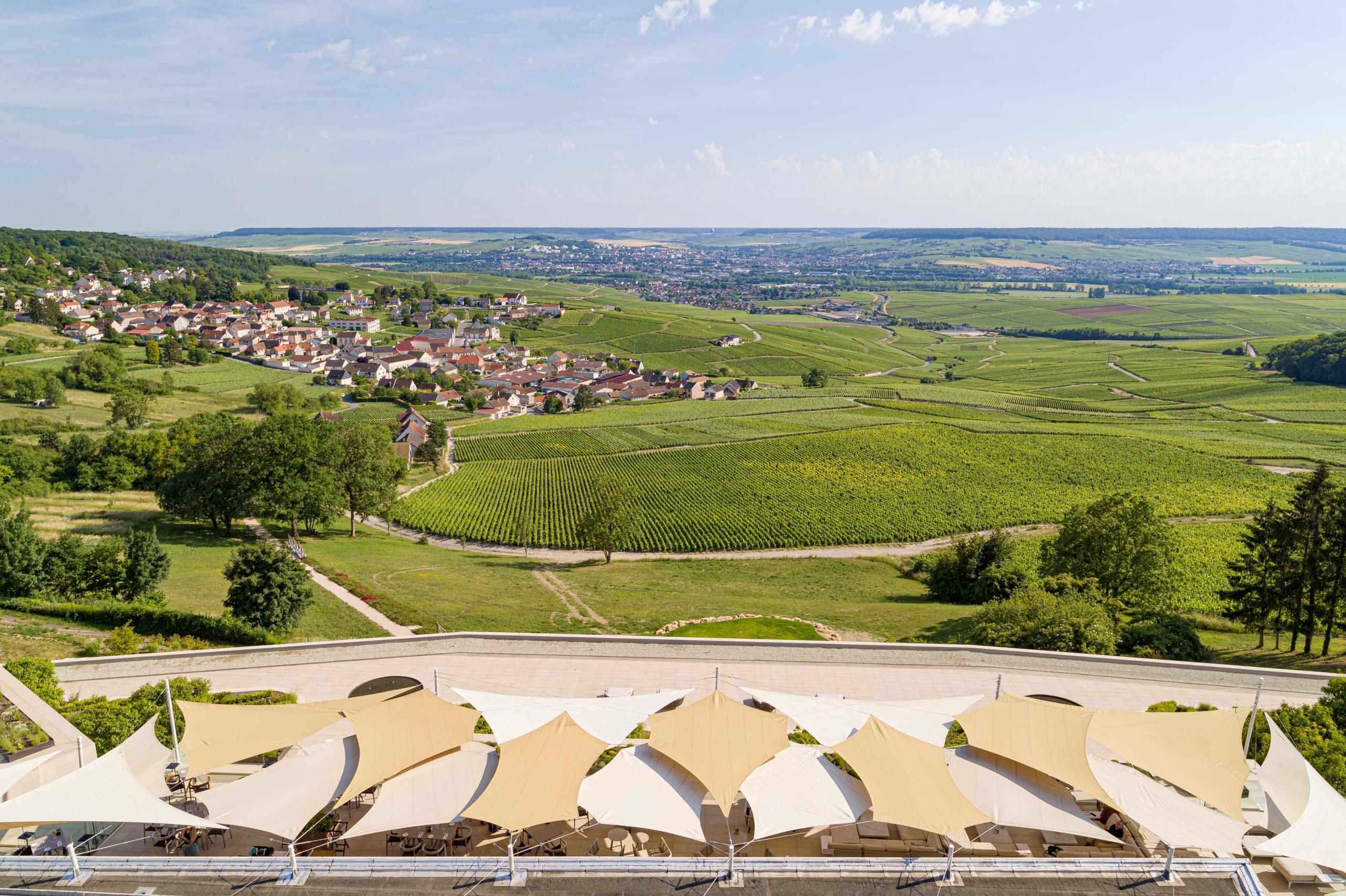 Royal Champagne Hotel & Spa: expansive vineyard landscape with sunlit fields, villages, and hotel terrace in foreground