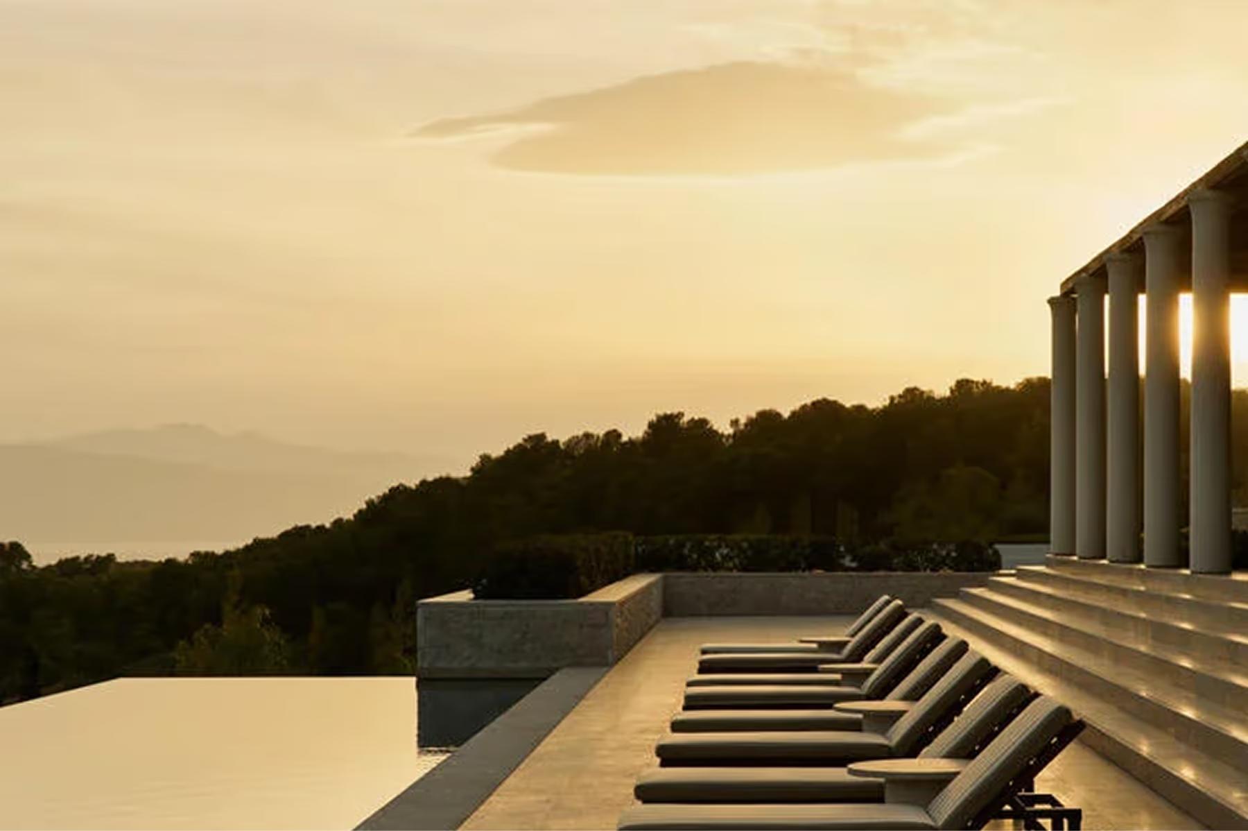 Waterside loungers at sunset with mountains and reflected sky
