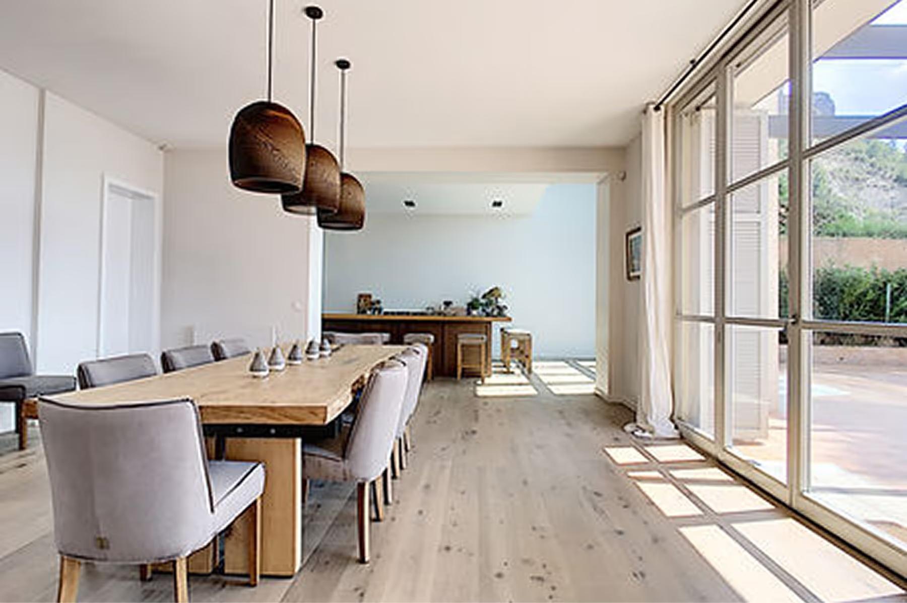Dining table set for meal on roofed terrace with sea view and Mediterranean trees