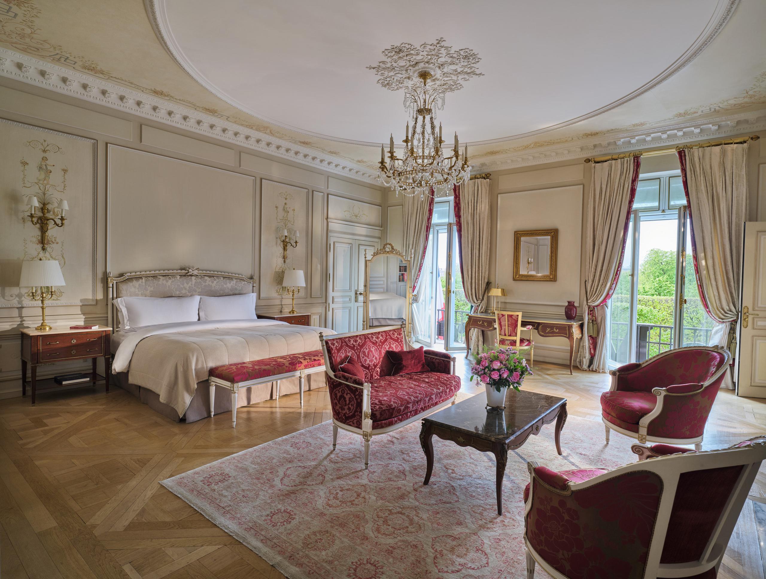 Le Meurice: a grand suite with queen bed, velvet upholstery, chandelier, and ornate ceiling details
