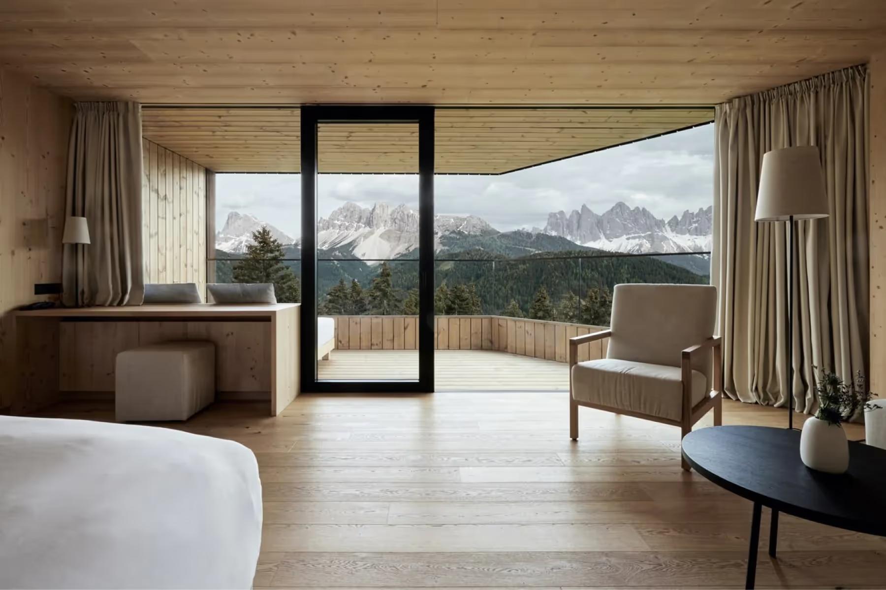 Forestis: a guest bedroom with clean lines, light color palette, and a window overlooking the surrounding landscape
