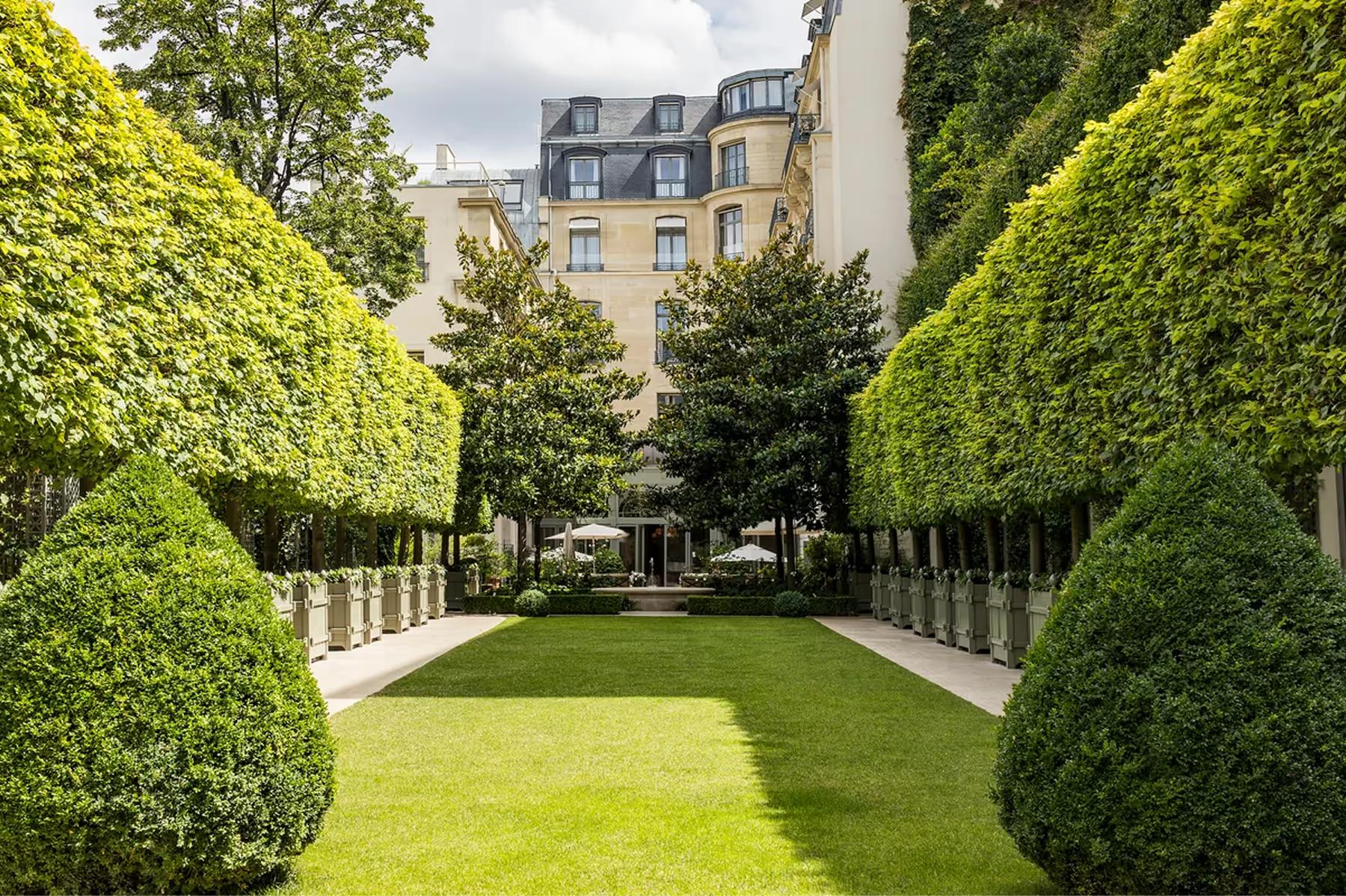 Ritz Paris: the private garden with sculptured hedges, white fencing, and views of the Paris facade