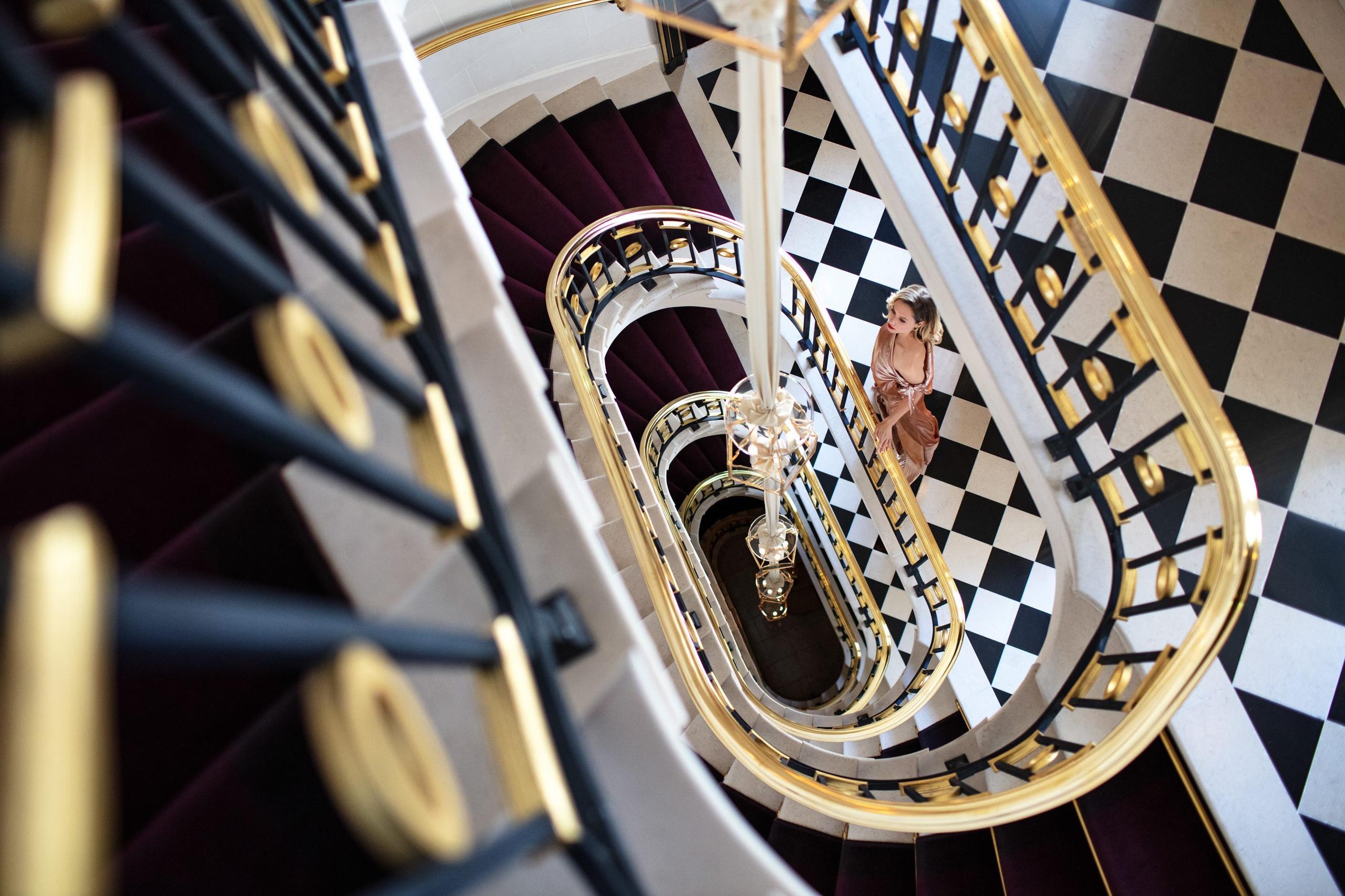 An overhead view of a spiraling staircase with black and white checkerboard pattern