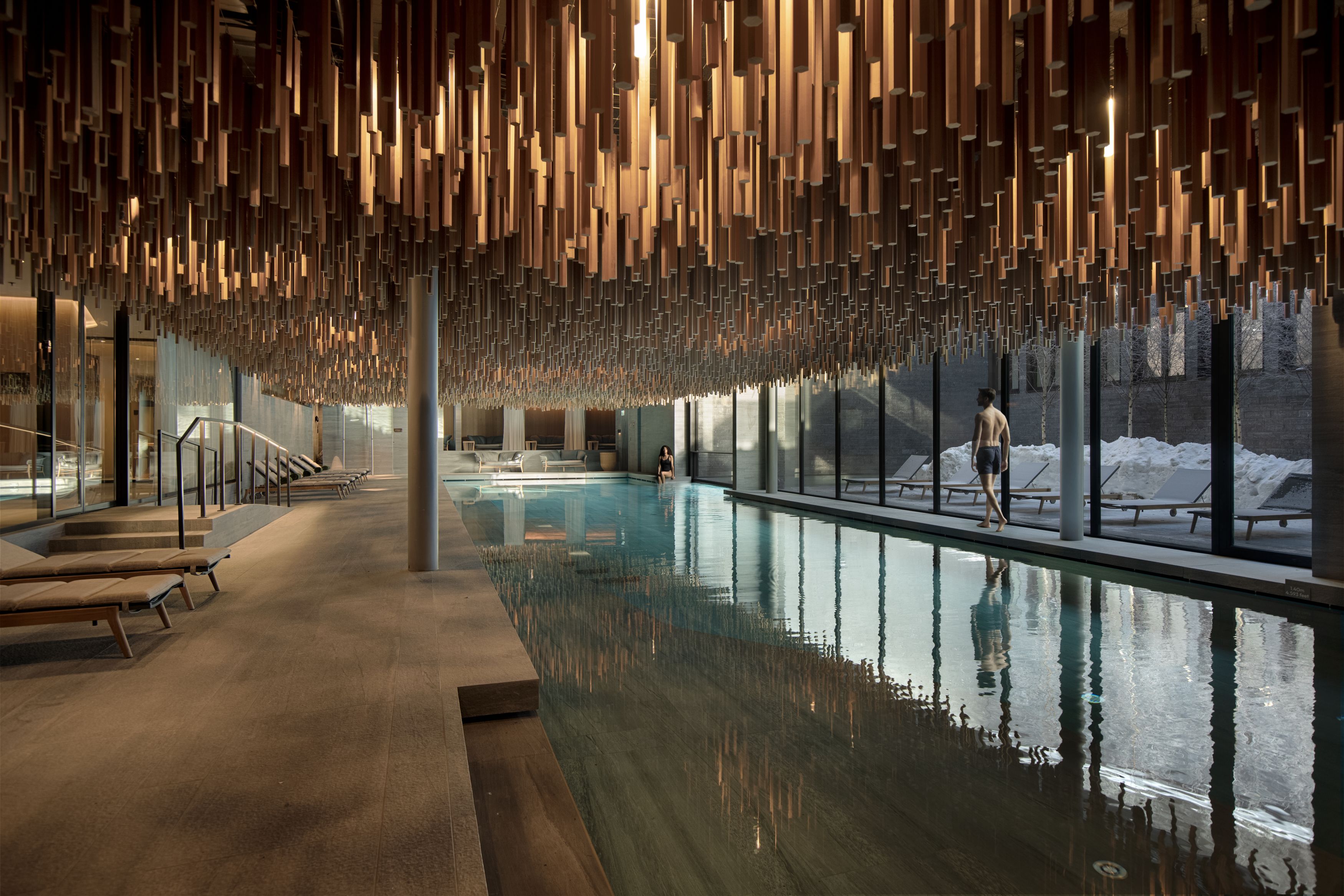 The indoor pool at Six Senses Crans-Montana under a ceiling of suspended timber battens