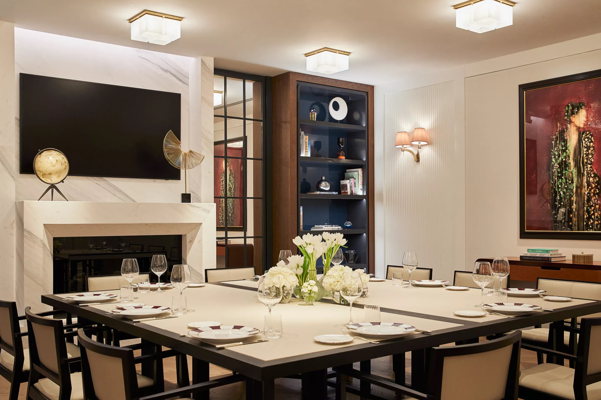 Rosewood Villa Magna: a dining room with fireplace, dark wood shelving, and black formal dining table