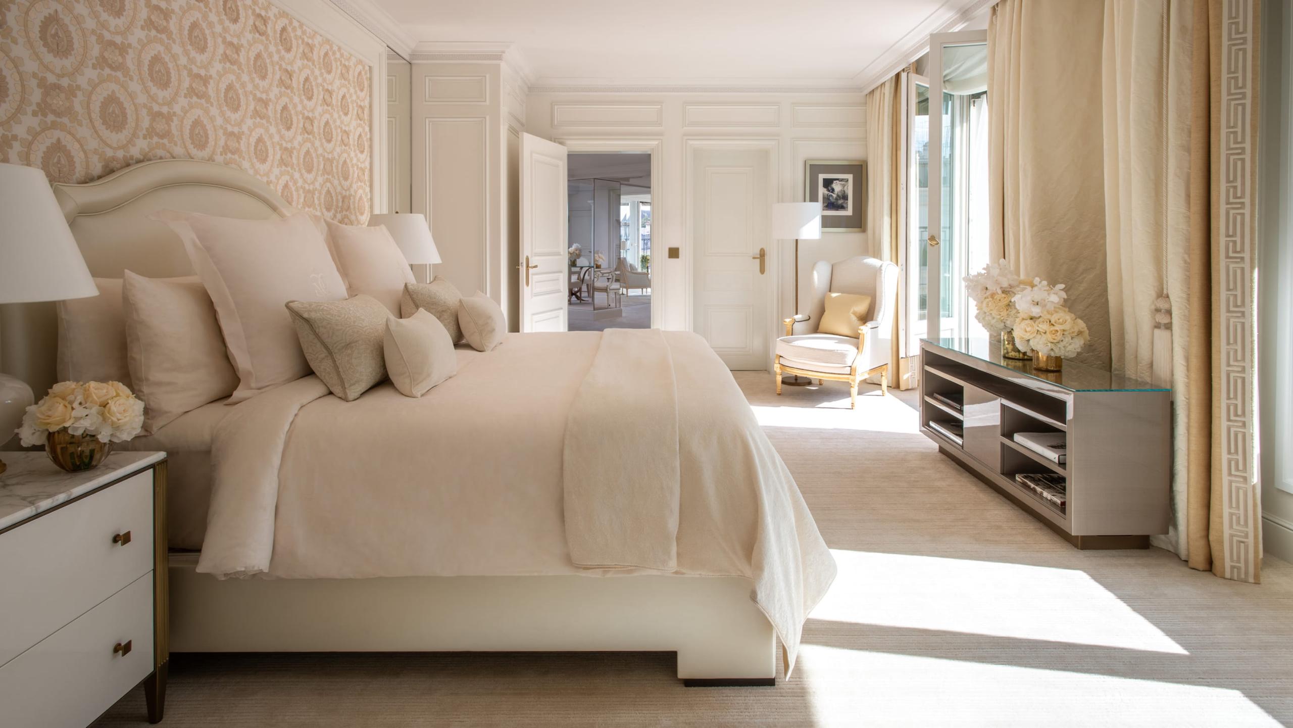 Four Seasons Hotel George V: a bedroom with textured headboard, cream linens, and soft light from tall windows