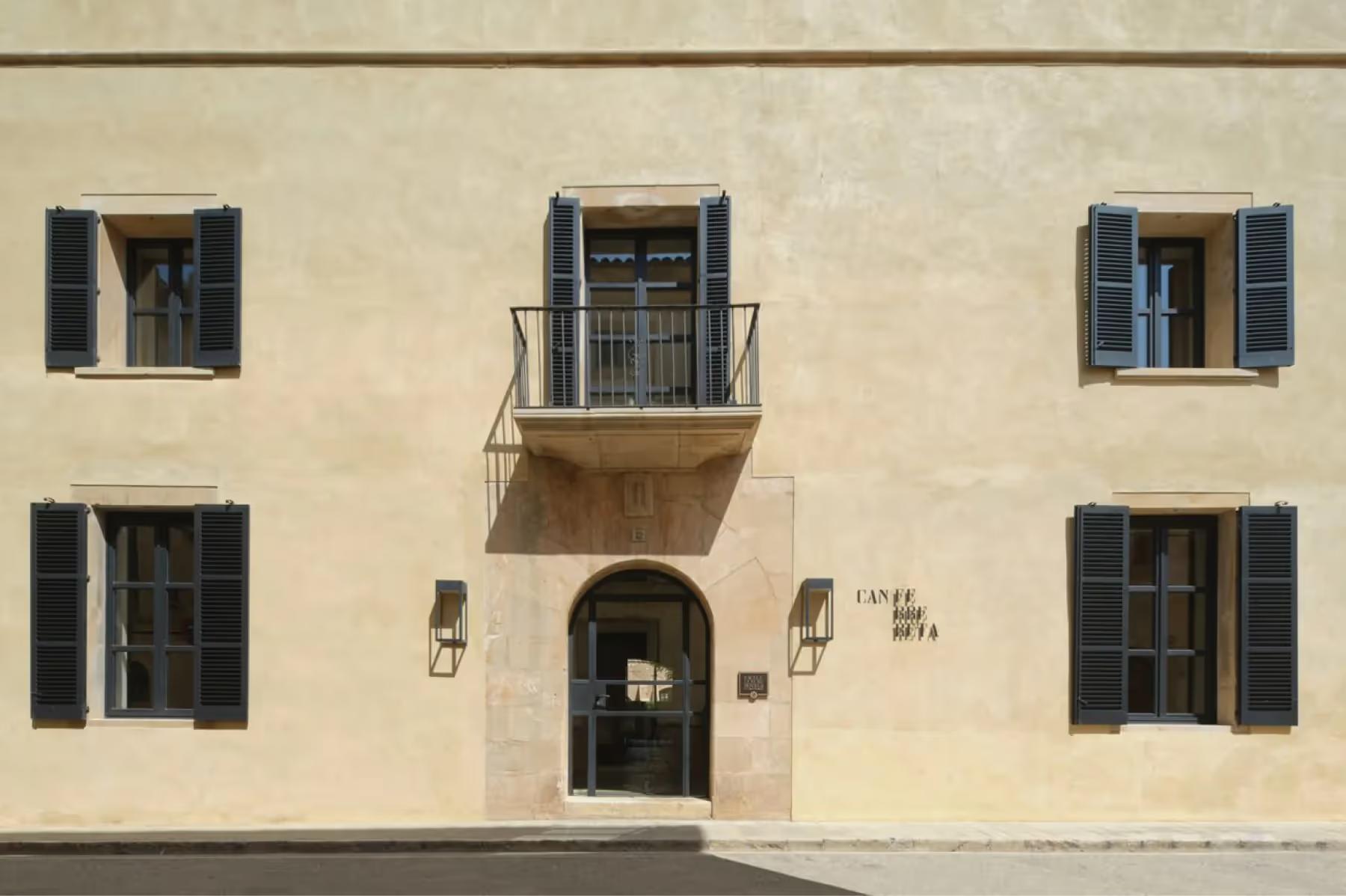 Exterior facade with traditional stone architecture and dark shutters