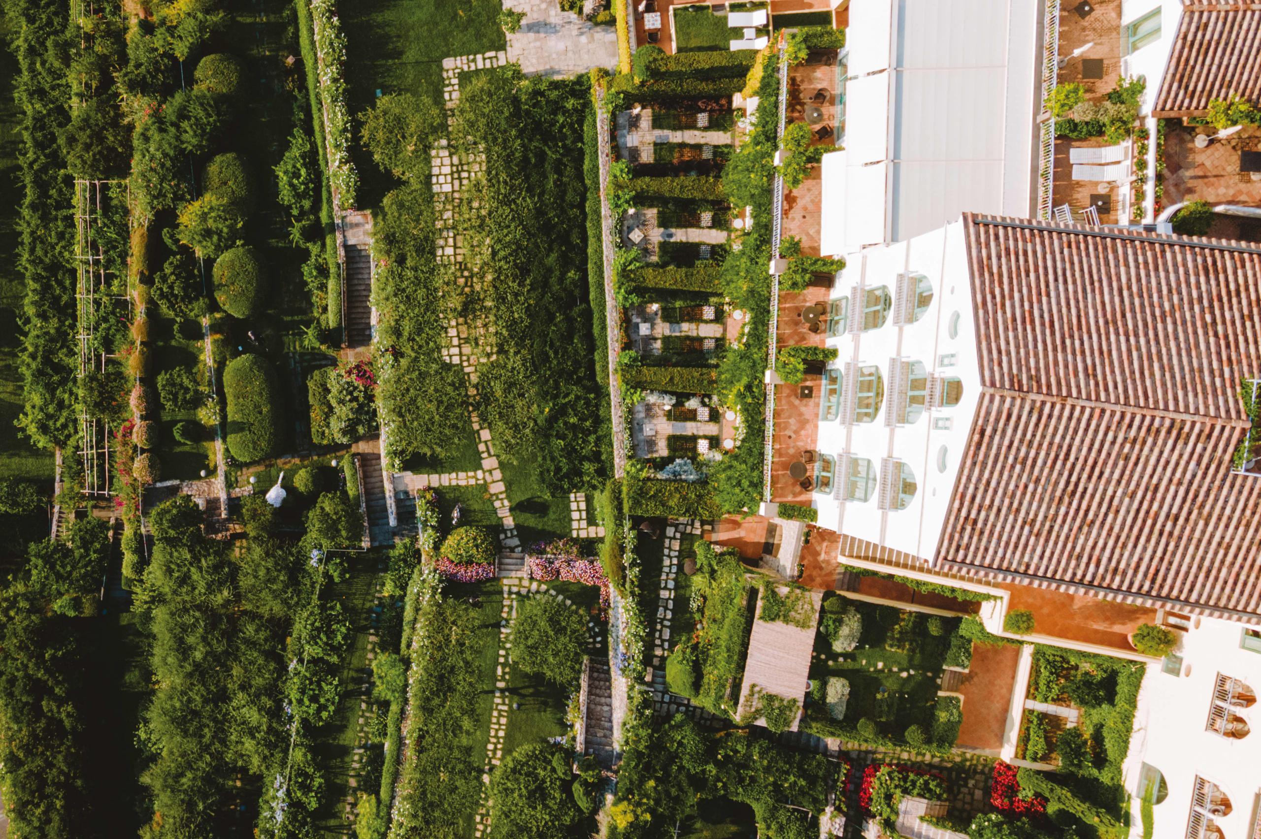 Caruso: aerial view of terraced palazzo with striped gardens, pathways, and Mediterranean coastline