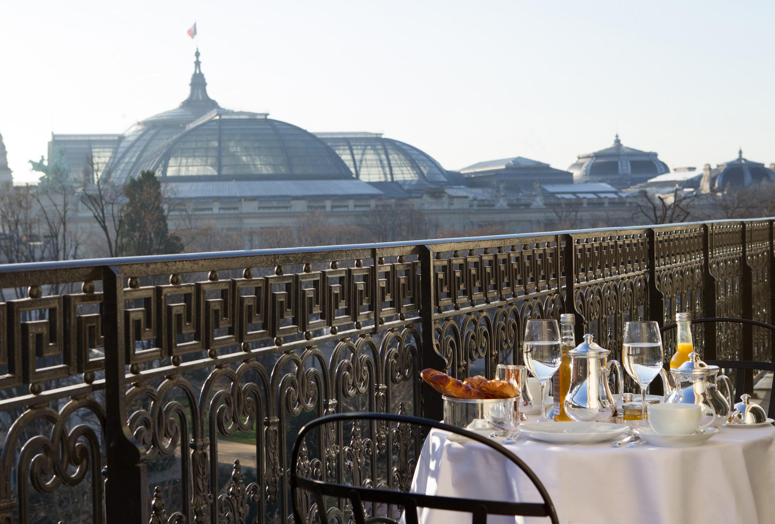 A rooftop dining table overlooking Paris with domes and architecture visible