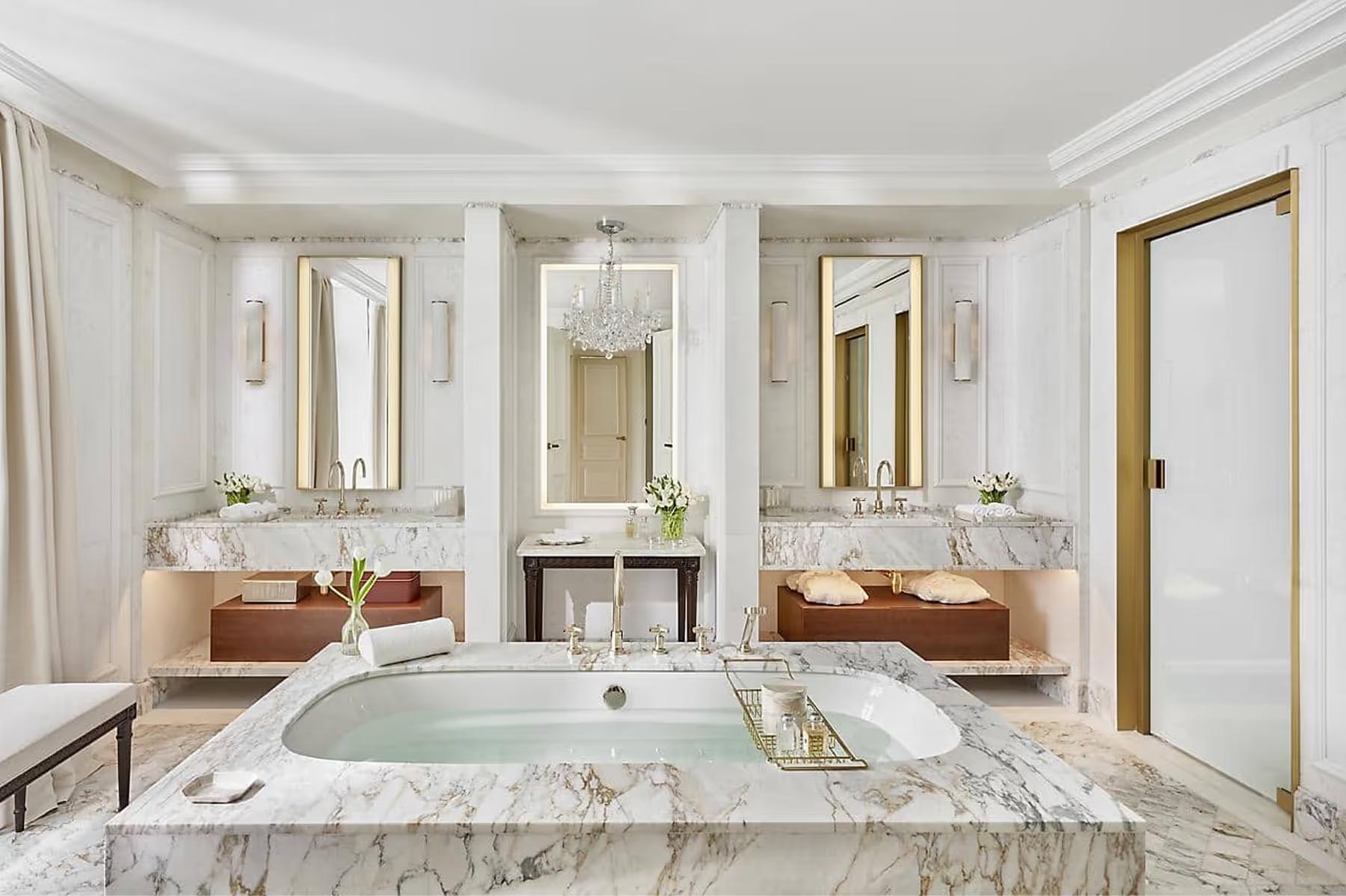 Spa bathroom with marble vanity, freestanding tub, and jewel-toned accents