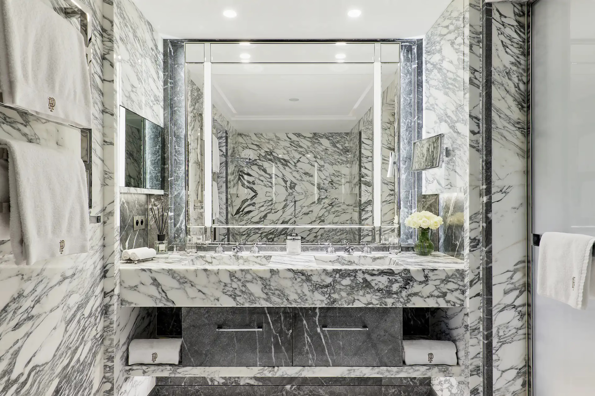 Marble bathroom with double vanity, large mirror and minimalist fixtures