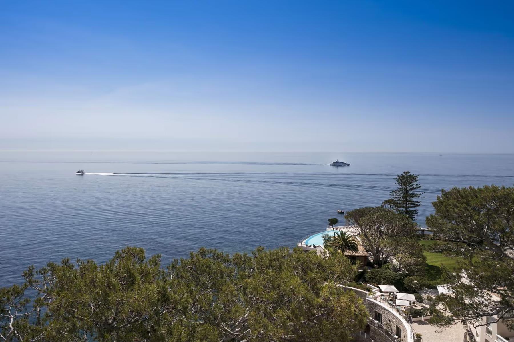 Hotel Cap-Estel: a calm Mediterranean seascape with rocky shoreline in the foreground