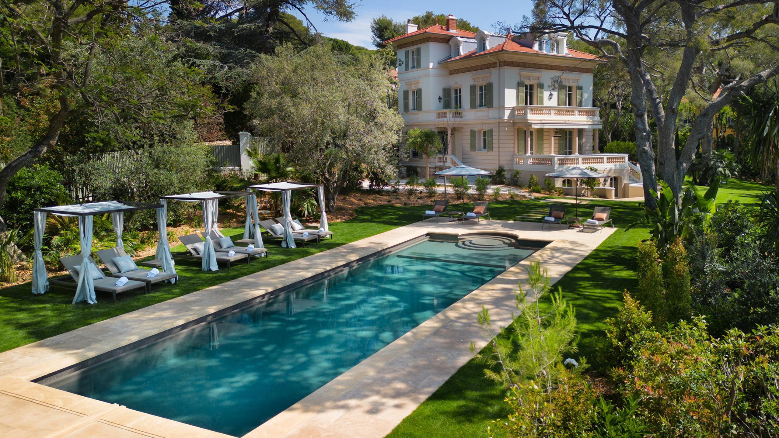 Grand-Hôtel du Cap-Ferrat: terracotta villa with pool and white lounge chairs in gardens
