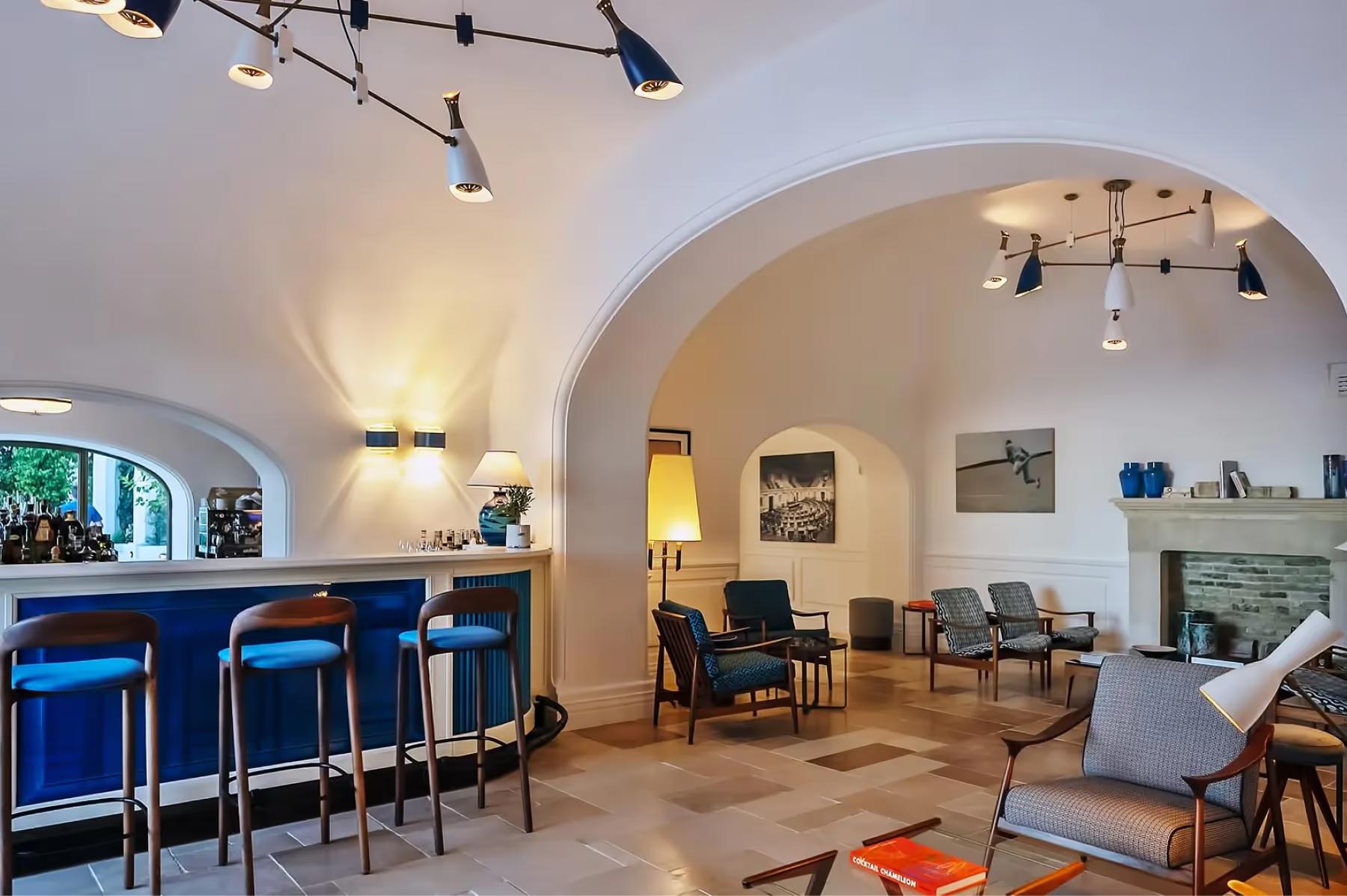 Borgo Santandrea: bar area with blue velvet seating and arched stone ceilings, light fixtures overhead