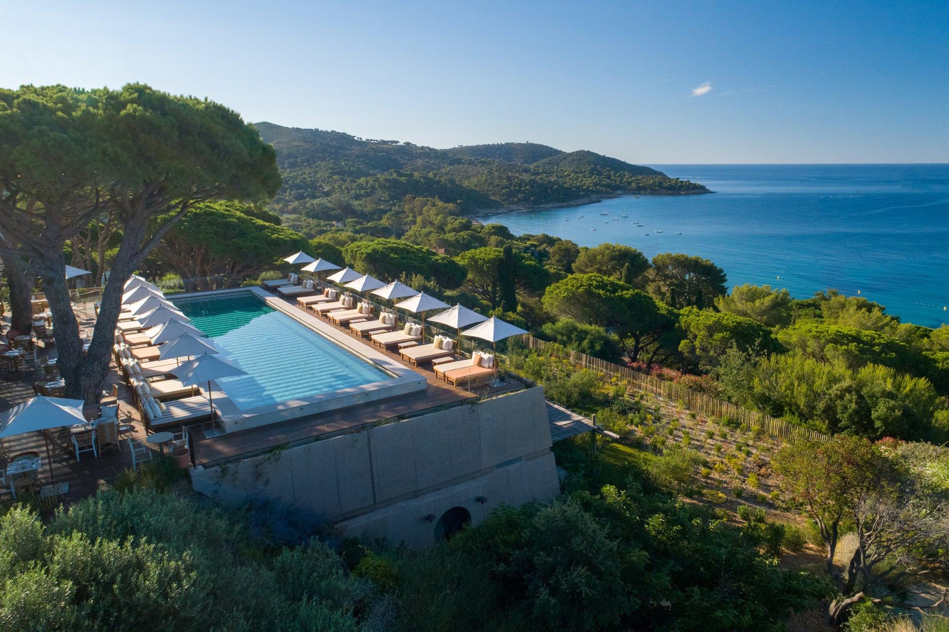 Lily of the Valley: pool with loungers and umbrellas on cliff overlooking blue Mediterranean