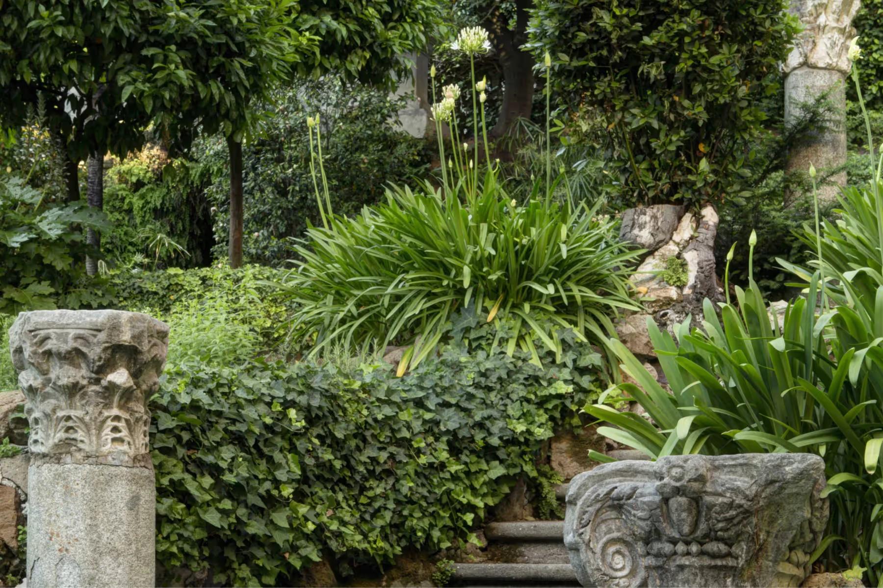 Hotel de Russie: garden passage with stone ornaments and layered plantings