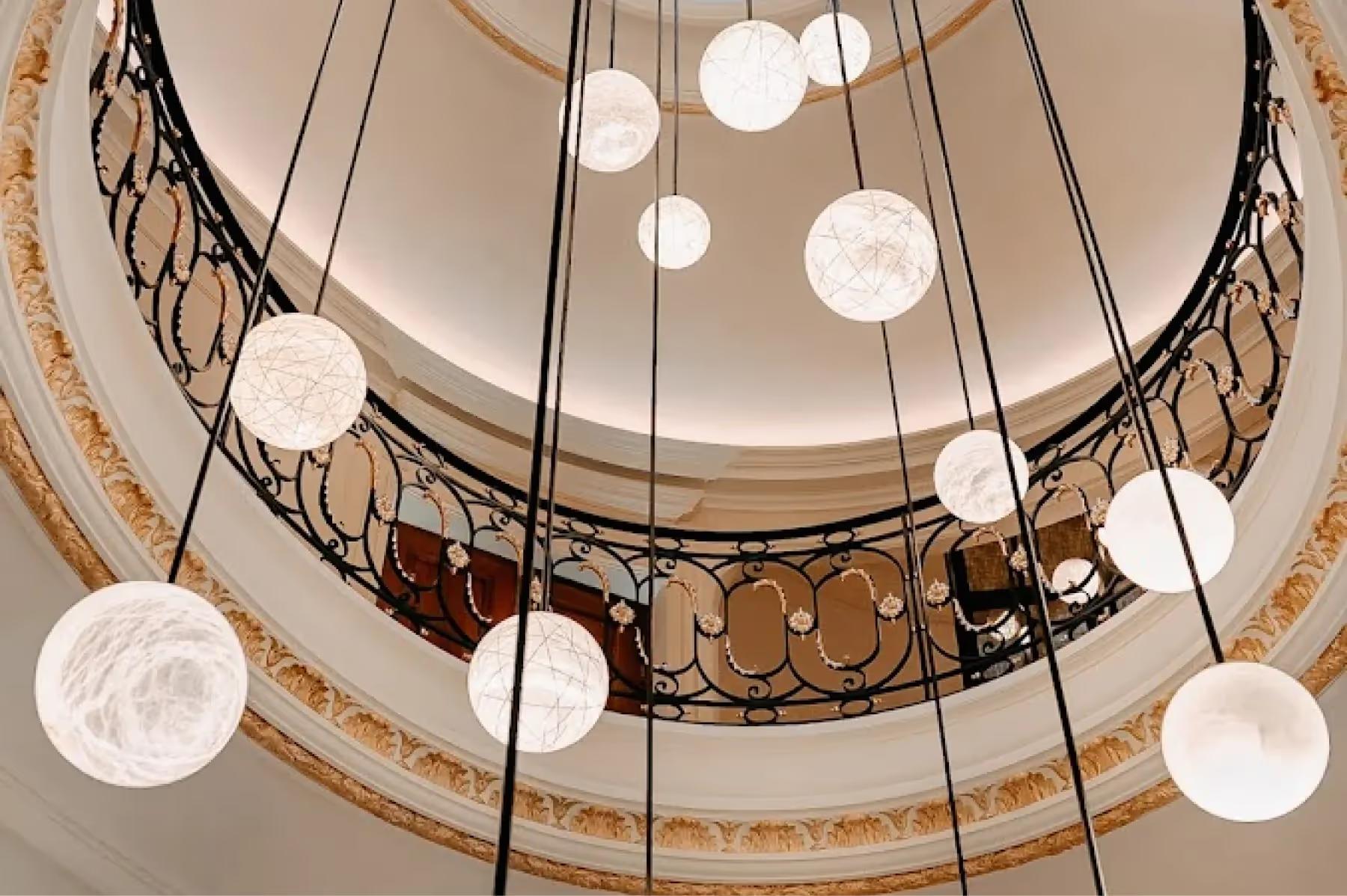 Maison Villeroy: a central foyer with arched ceiling, pendant lights suspended above wooden and stone finishes