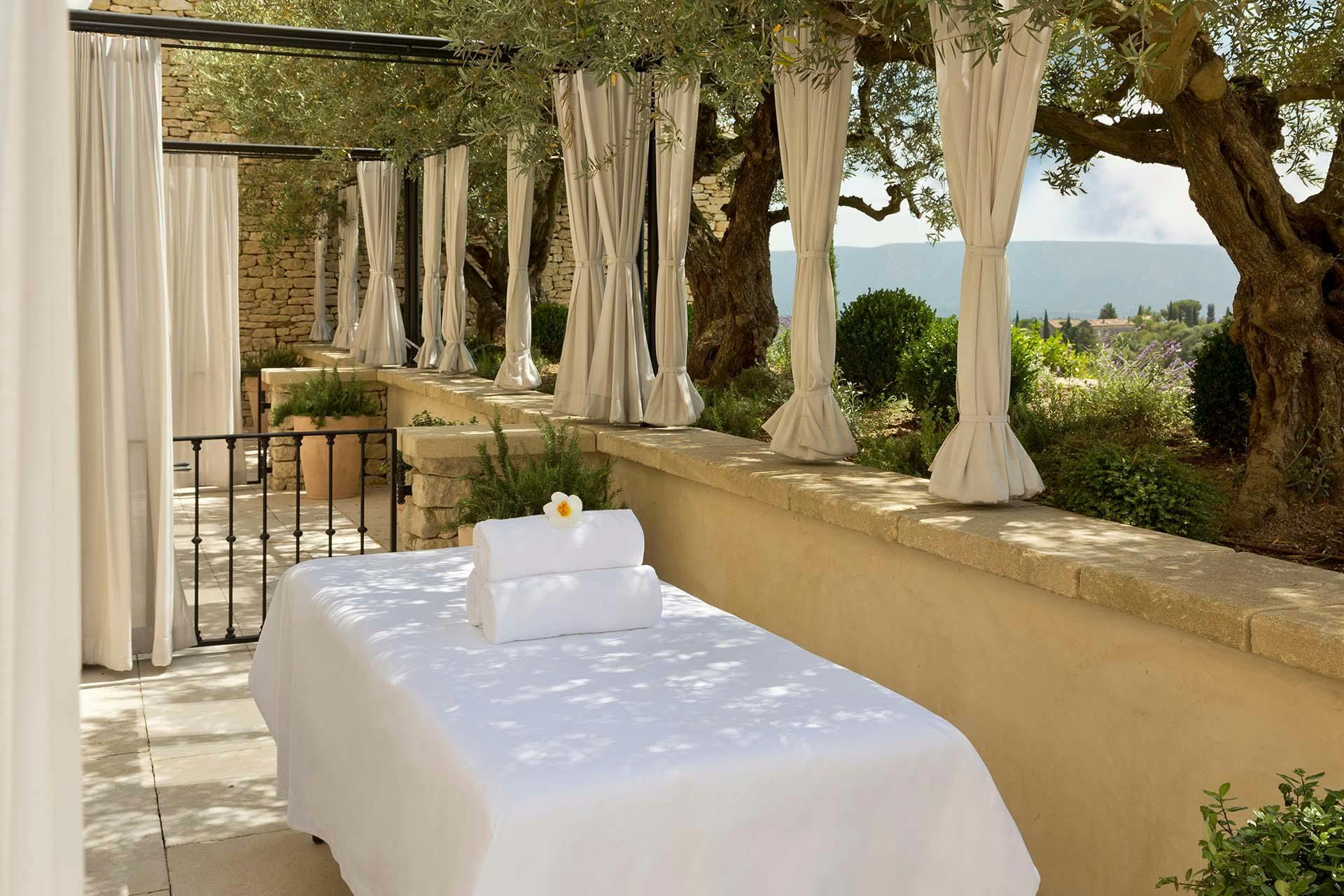 Airelles Gordes, La Bastide: indoor lap pool with coffered ceiling and cream-colored lounge chairs