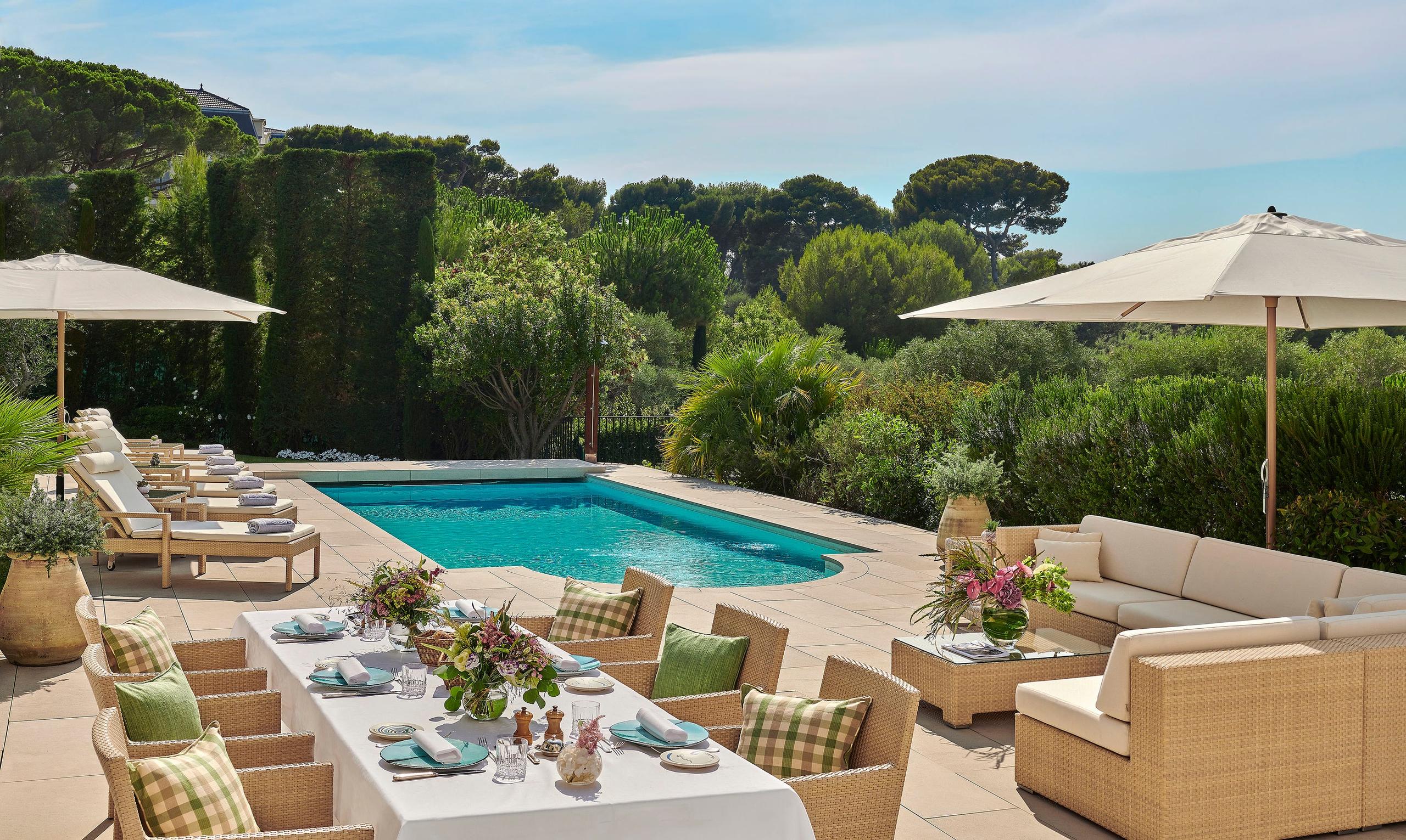 Hôtel du Cap-Eden-Roc: a waterfront terrace with loungers, daybeds, and a view of turquoise water and distant coastline