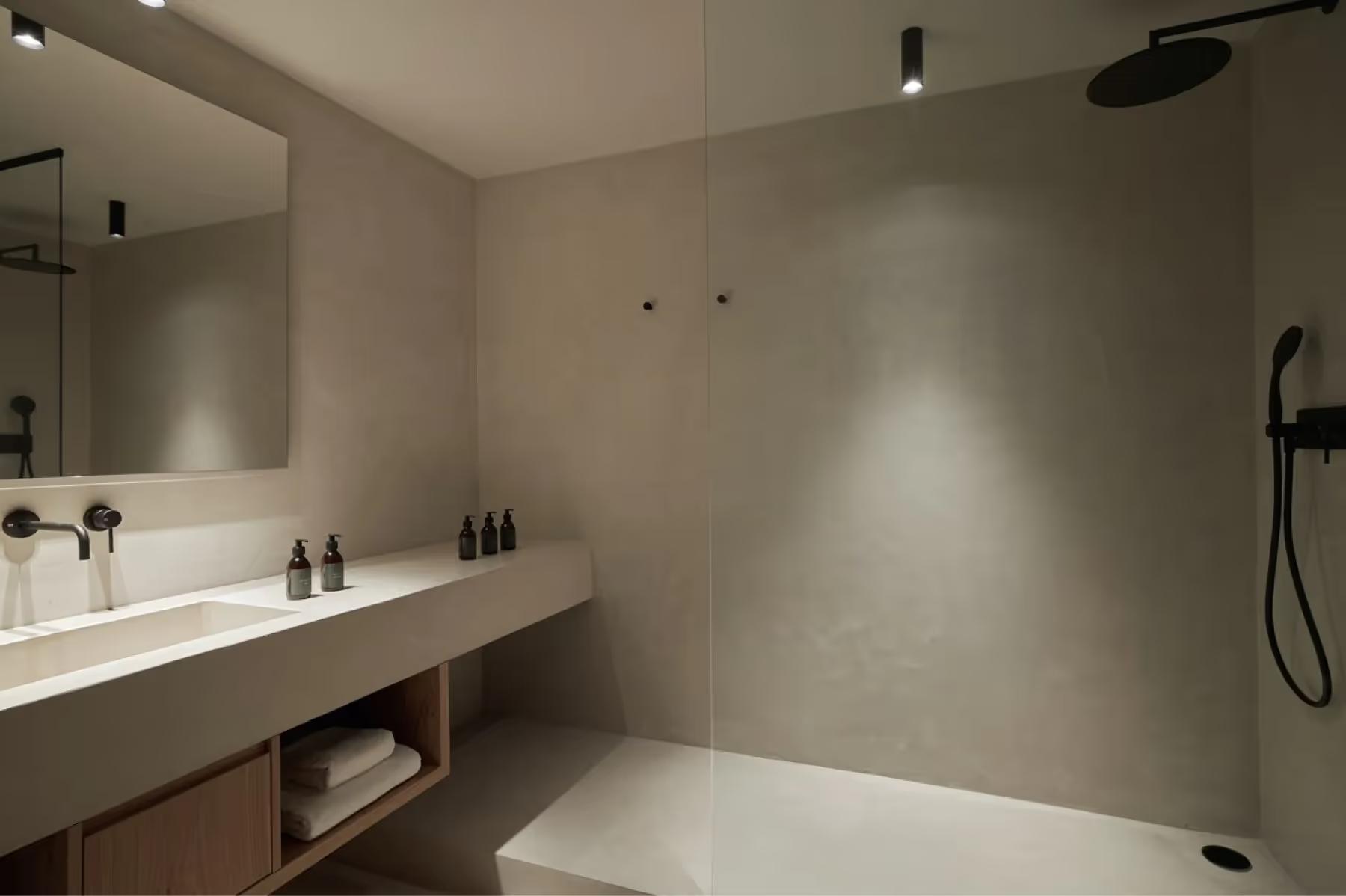 Forestis: a minimalist bathroom with light walls, a long white vanity, and an open shower area