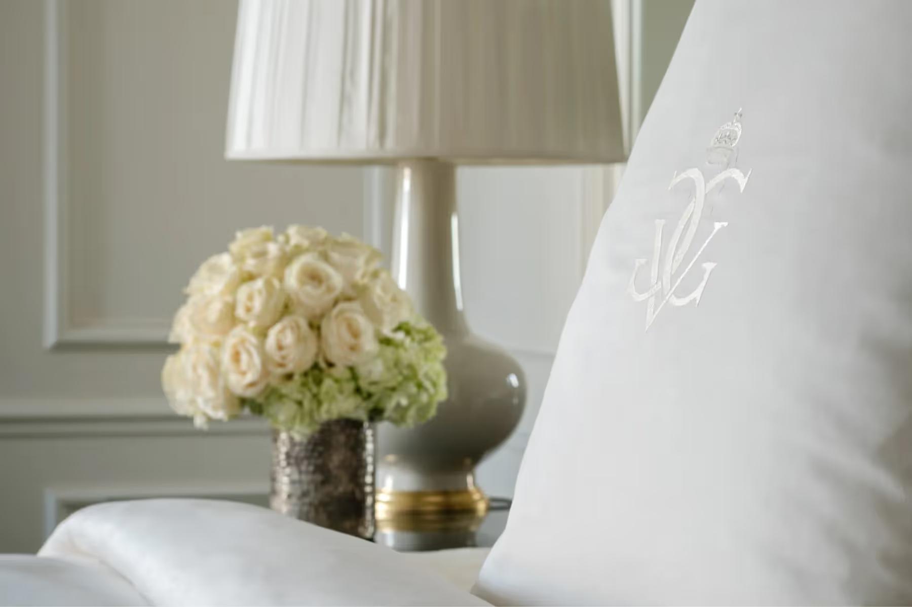Four Seasons Hotel George V: a bedroom with dark wood wardrobes, taupe drapery, and warm gold-toned lighting