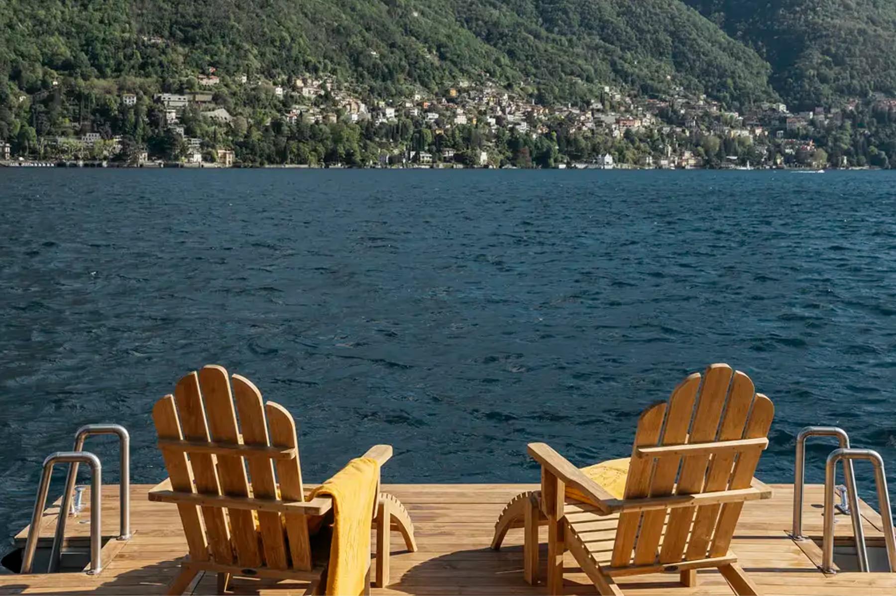 Passalacqua: two wooden Adirondack chairs on a deck facing Lake Como and mountains