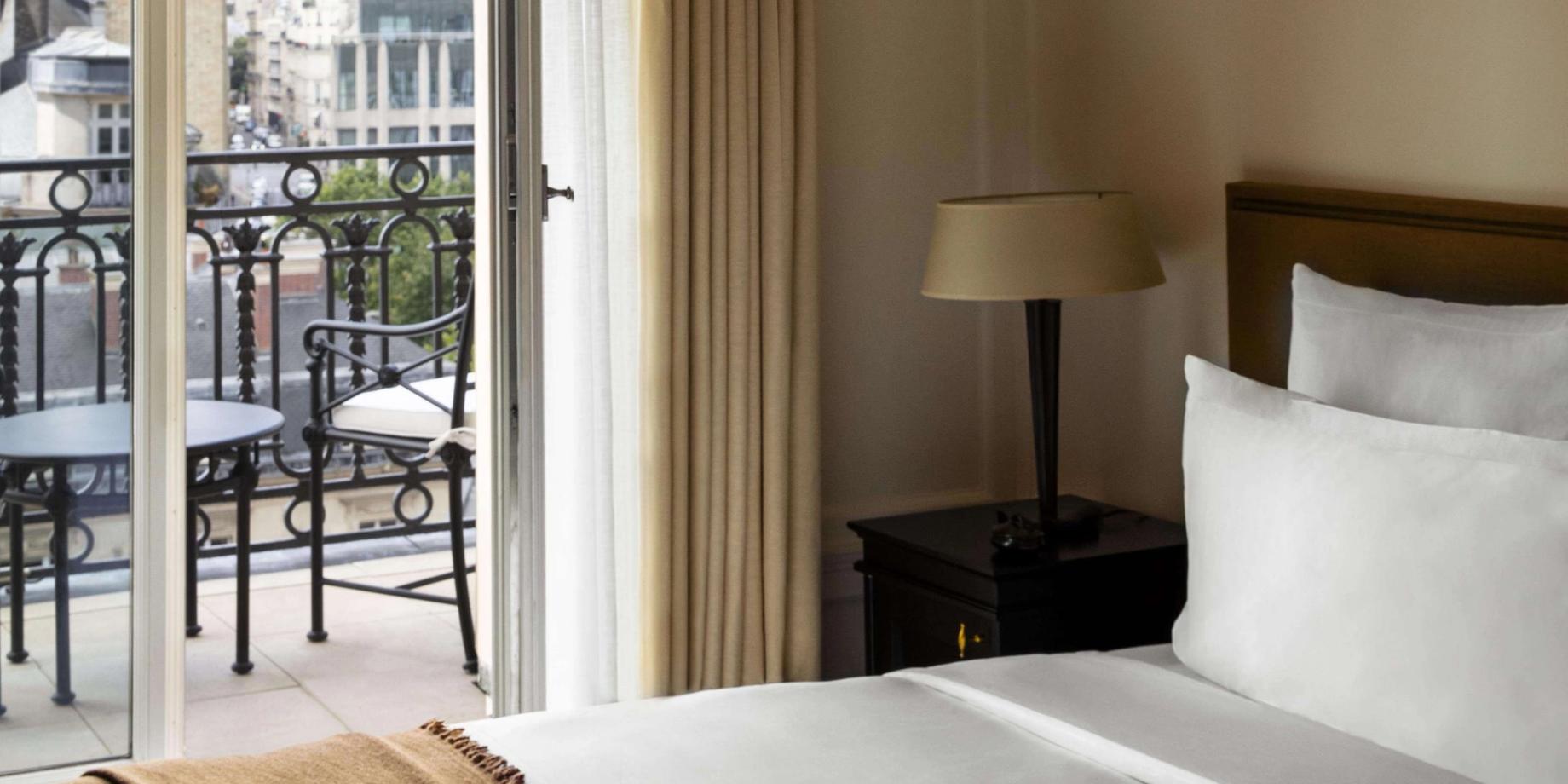 Hôtel Balzac: a hotel bedroom with a balcony overlooking Paris rooftops and the city