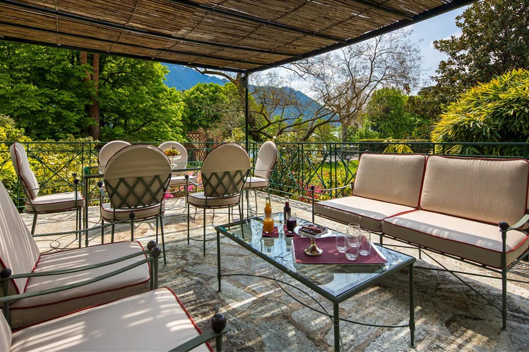 Shaded terrace with stone dining table and mountain and water views