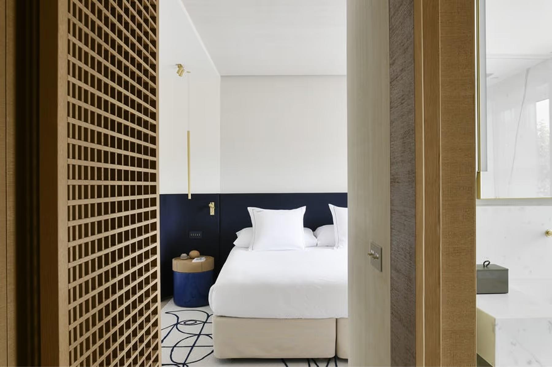 Hallway entry with wooden lattice door and white bedroom