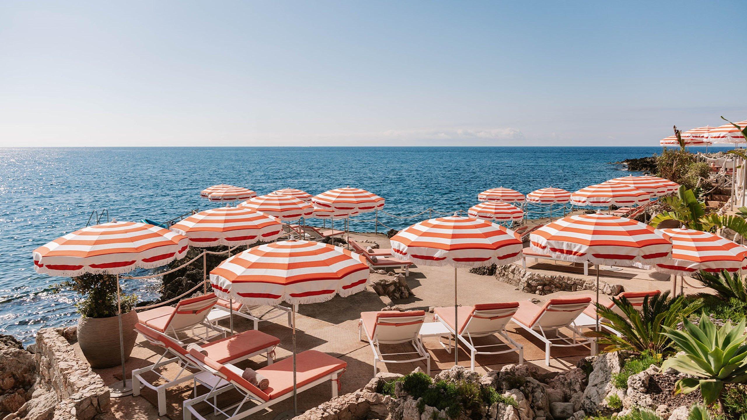 Maybourne Riviera: beach club with striped umbrellas on sand