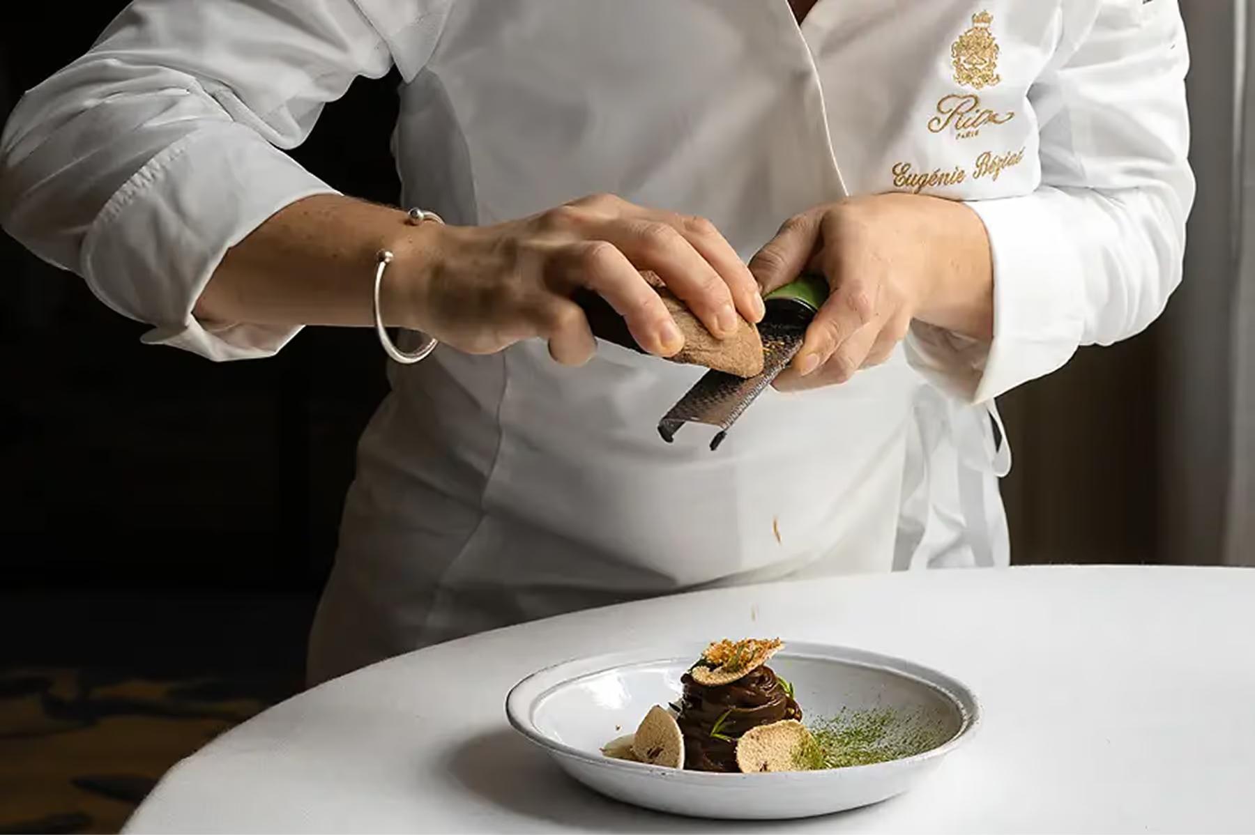 Ritz Paris: a chef’s hands preparing a plated dish with precision and artistry