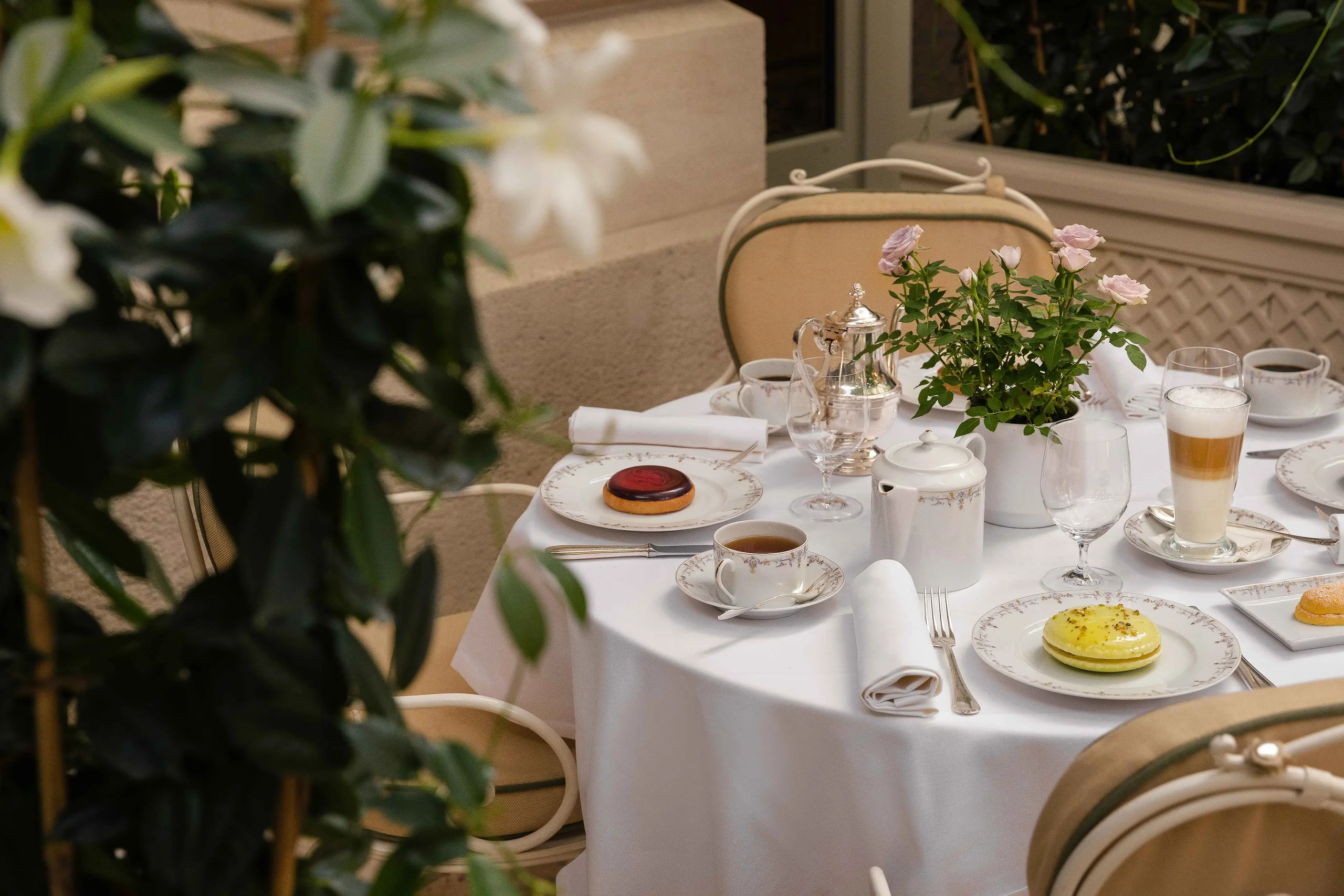 Ritz Paris: an intimate table setting with white linens, full place settings, and fresh floral arrangement