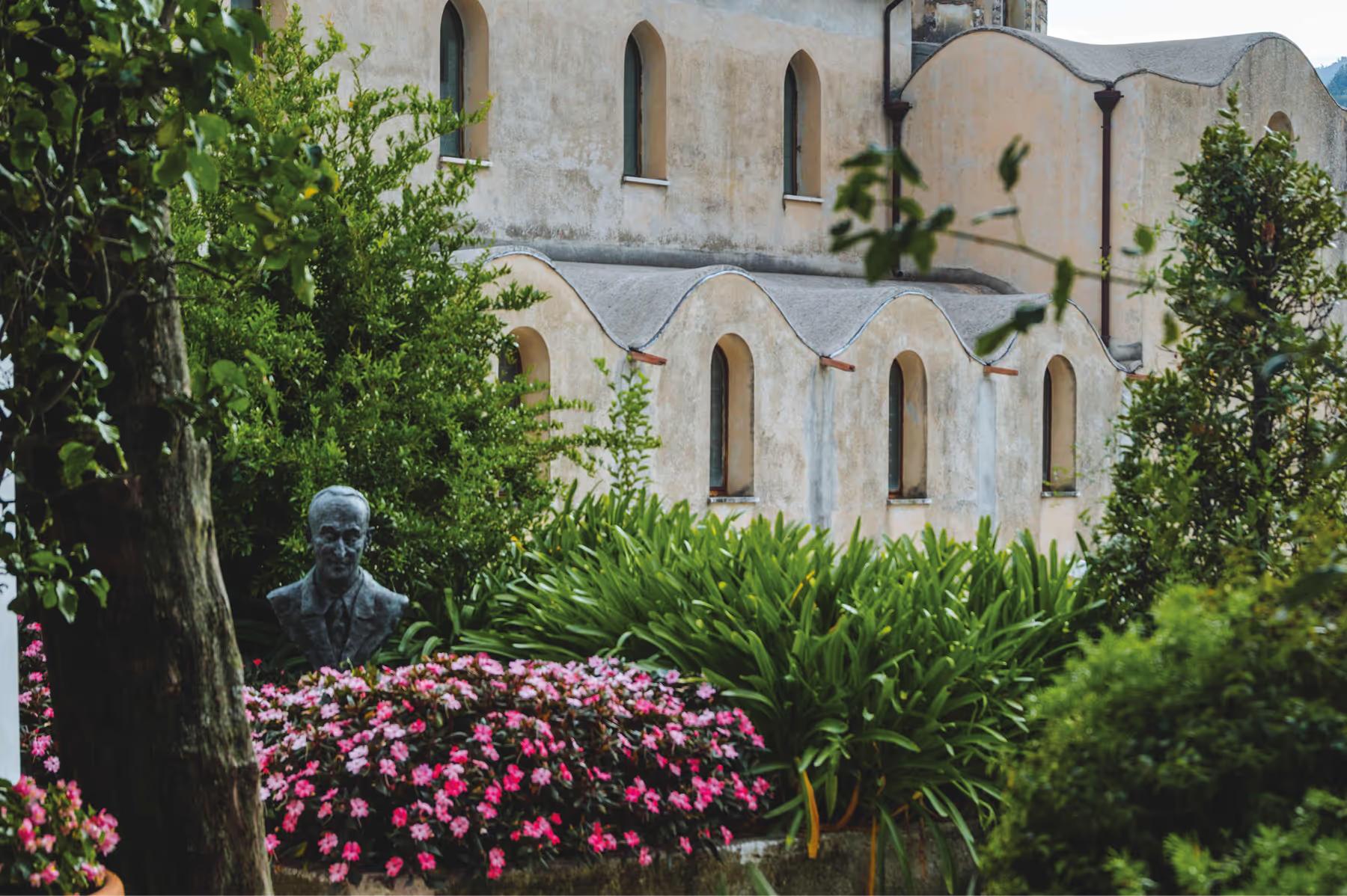 Caruso: Mediterranean palace exterior with flowering magenta plants and stone balcony overlooking coast