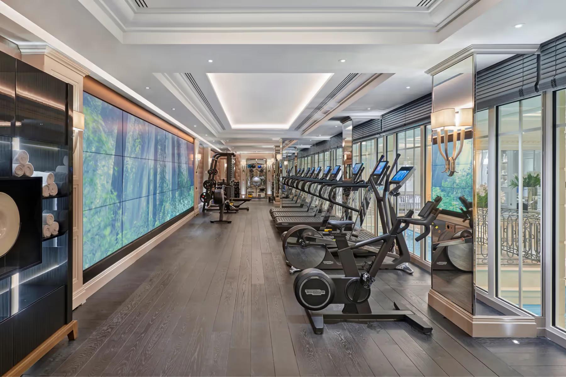 Four Seasons Hotel George V: a fitness center with stationary bikes along the windows and modern equipment