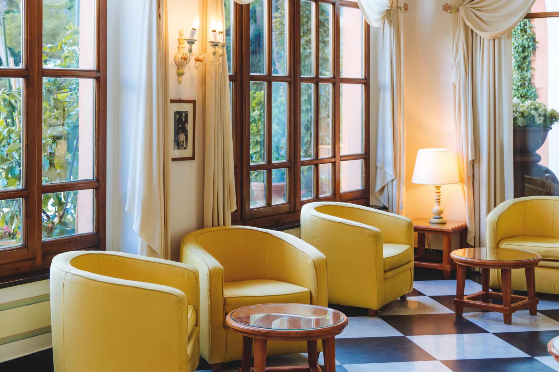 Splendido: a sitting room with yellow armchairs, wood-framed doors, and soft natural light