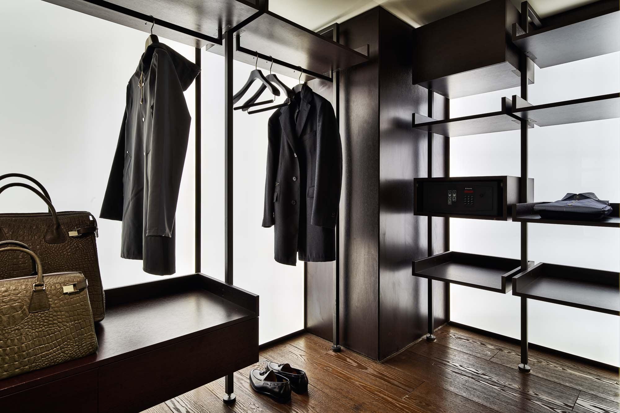 Mandarin Oriental Conservatorium, Amsterdam: walk-in wardrobe with dark shelving, coats on hangers, a safe, and two handbags