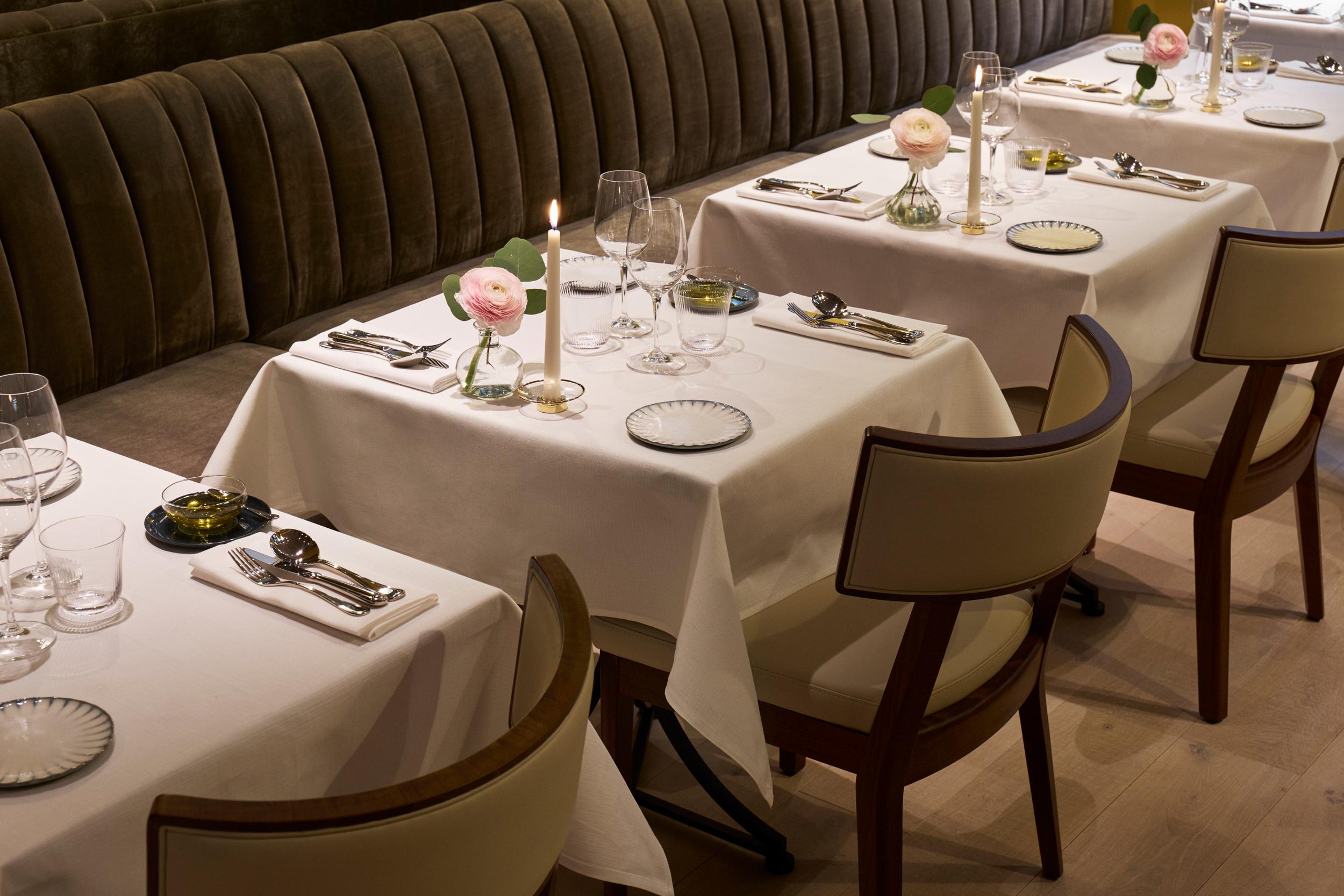 Villa Dagmar: dining room with curved banquette seating, neutral linens, and elegant table setup