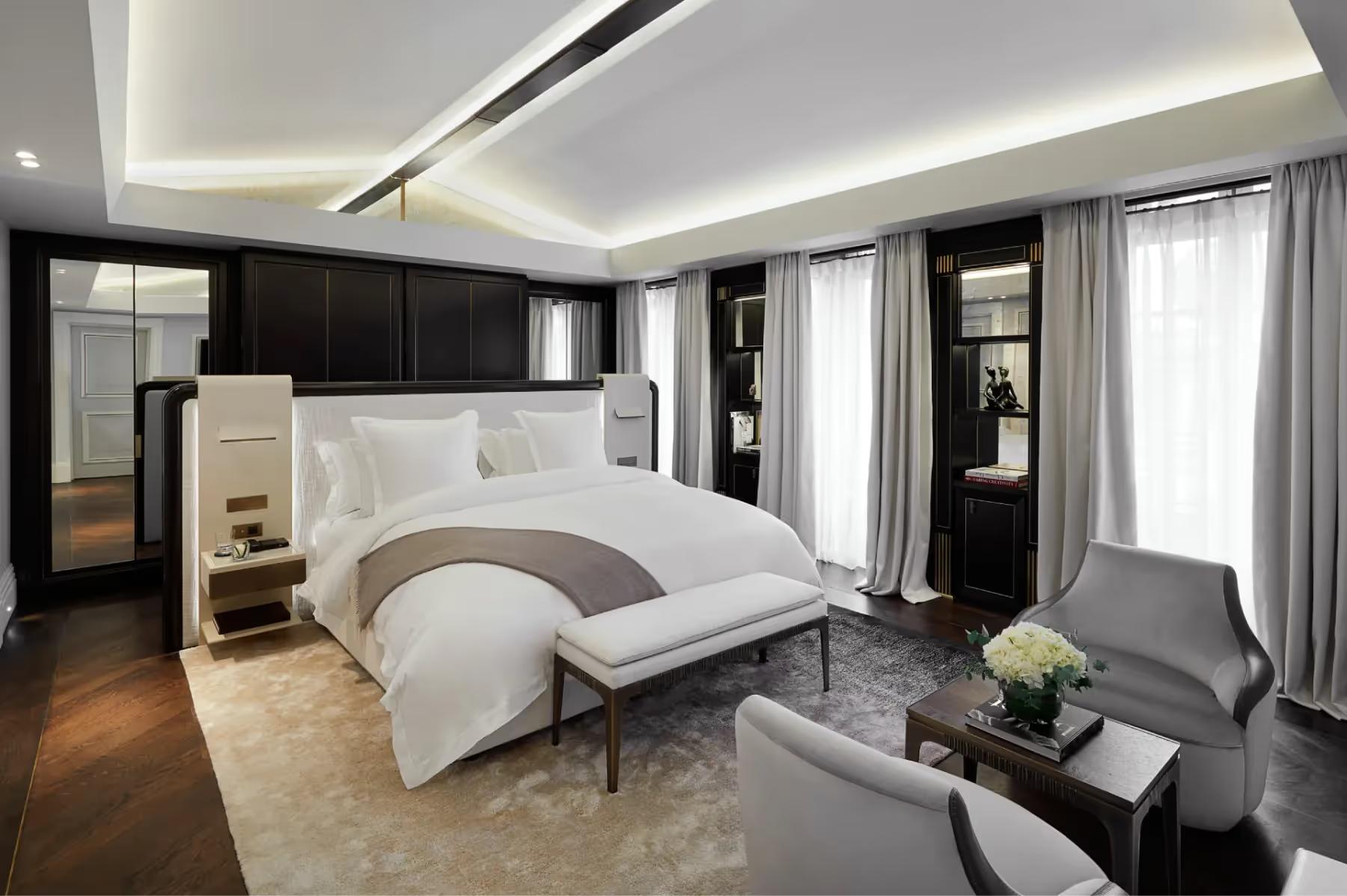 Maison Villeroy: a bedroom with black and white color scheme, modern ceiling lights, pale furnishings, and sheer window drapes