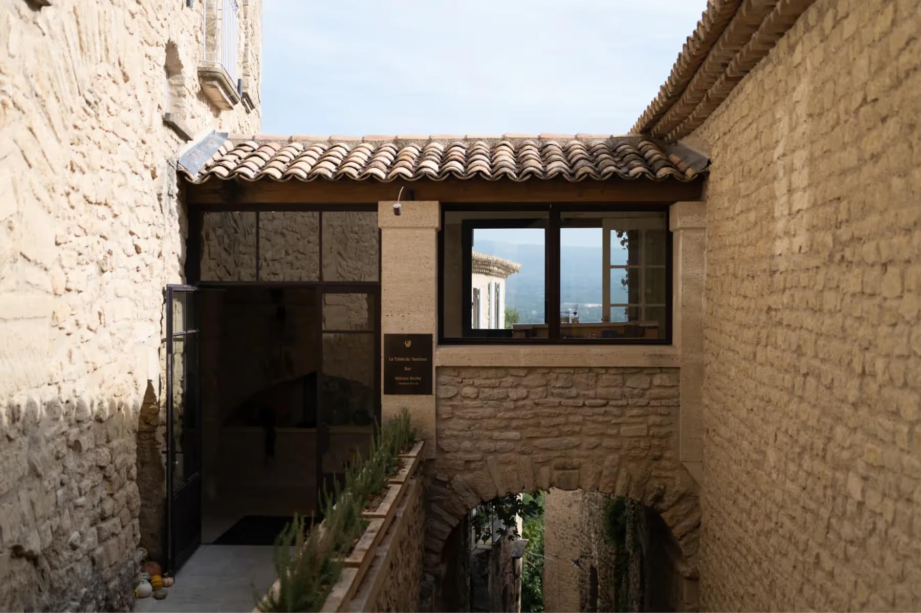 Hôtel Crillon le Brave: a narrow stone village passageway with restored masonry buildings and small windows