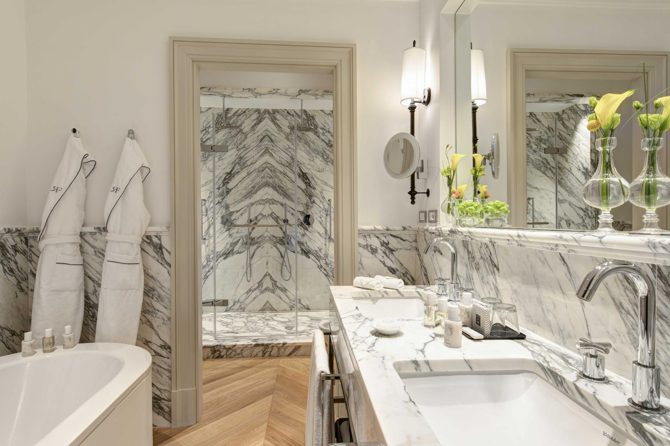 Hotel de Russie: marble bathroom with dual sinks, decorative panels, and white fixtures