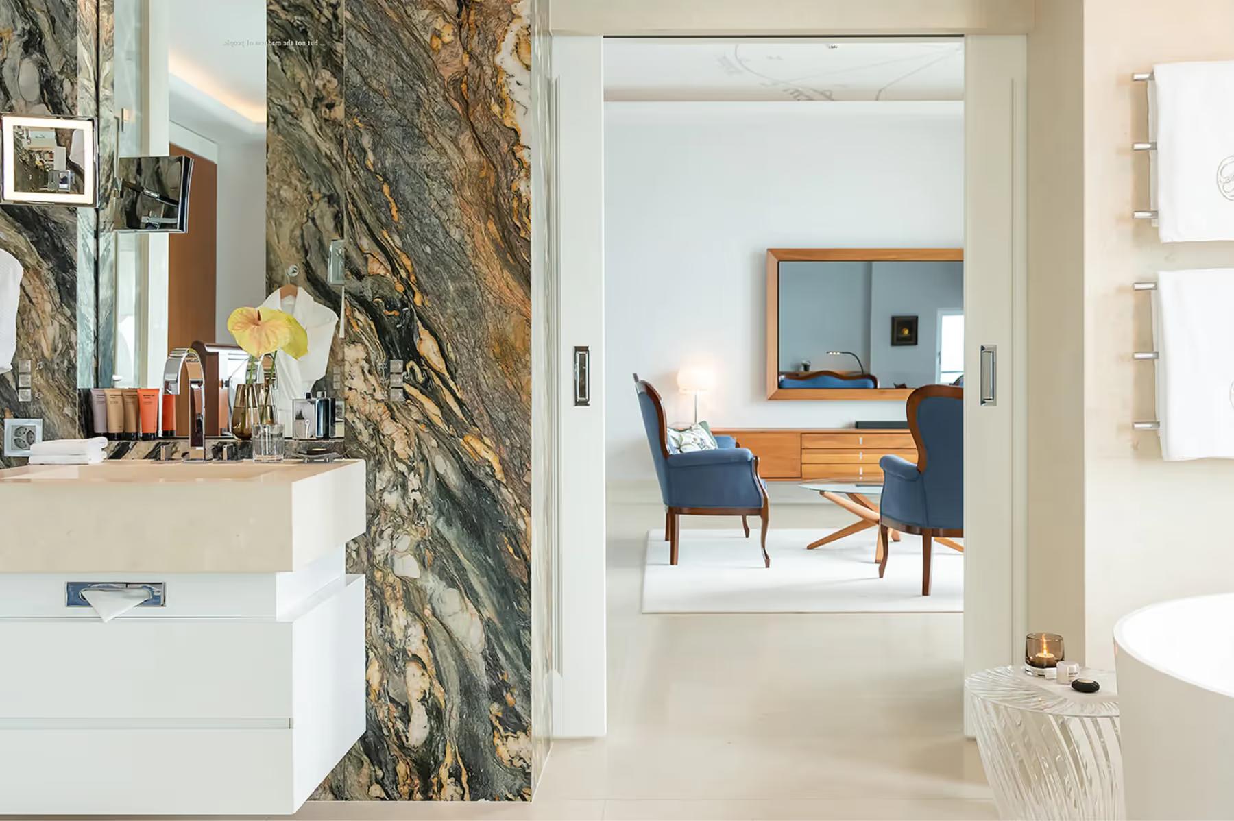 Bathroom with natural stone wall and view into bedroom