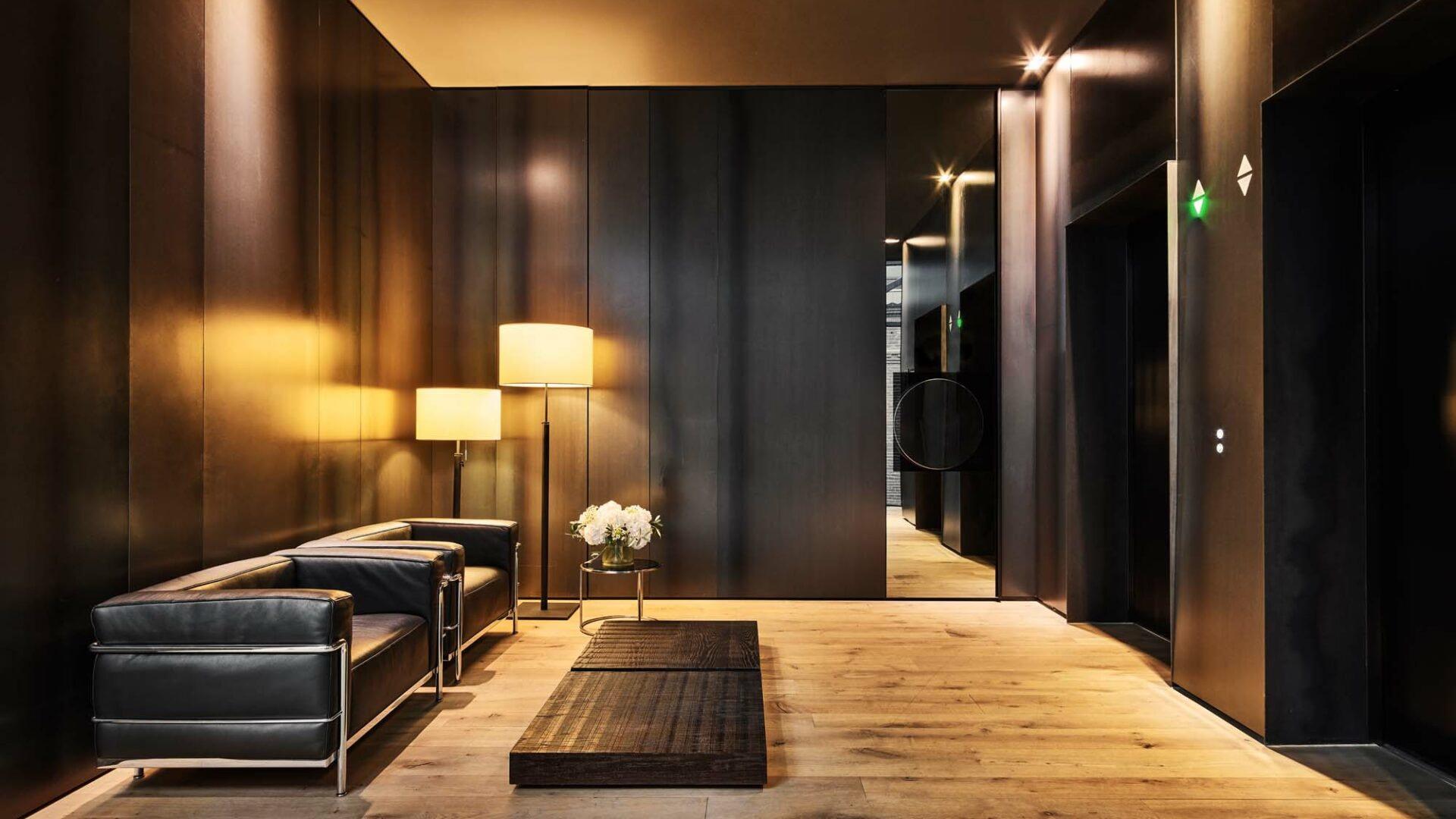 Contemporary entrance hall with dark timber accents, pendant lighting, and polished wood flooring